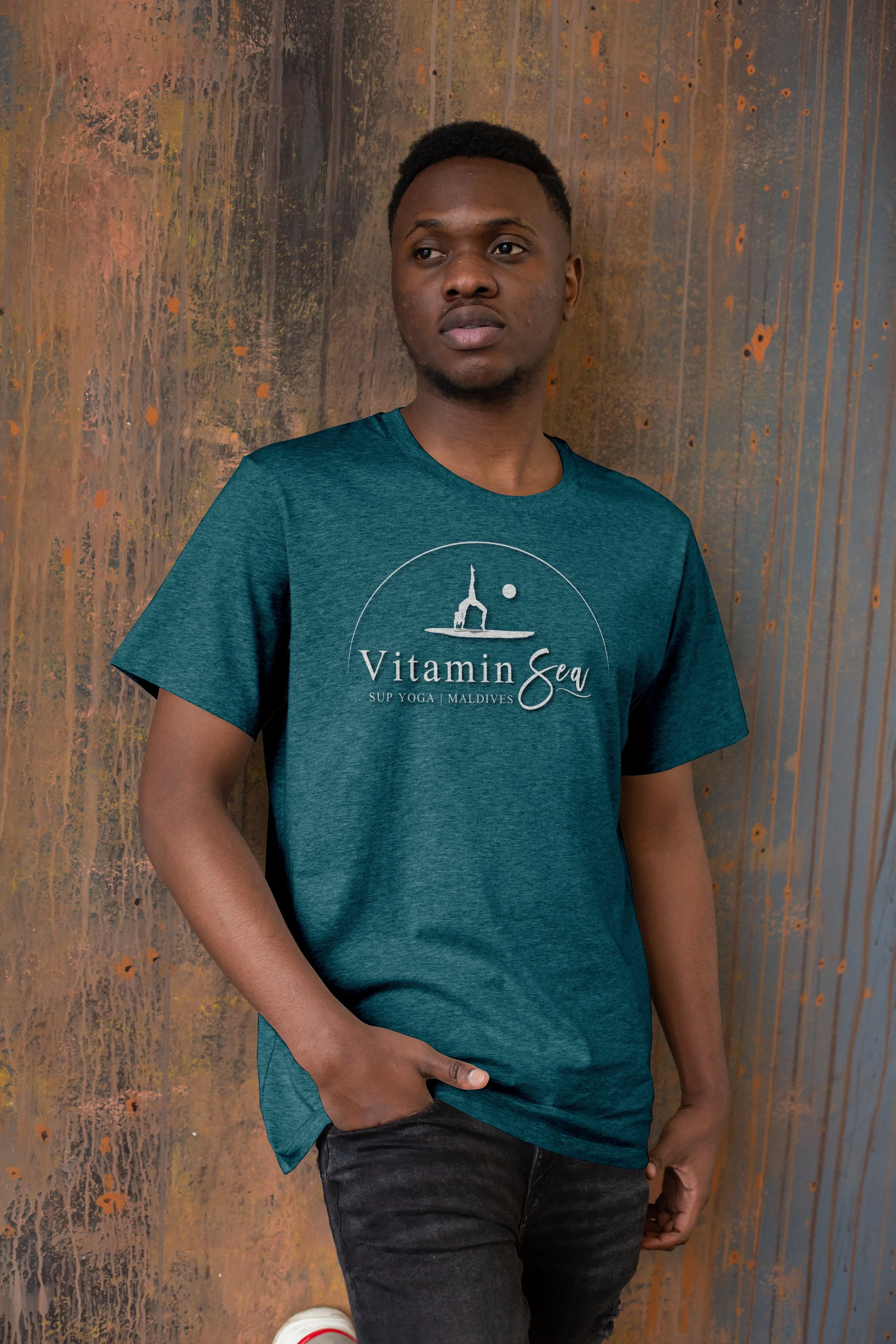 White logo mocked on dark blue shirt worn by person standing in front of rusted metal wall