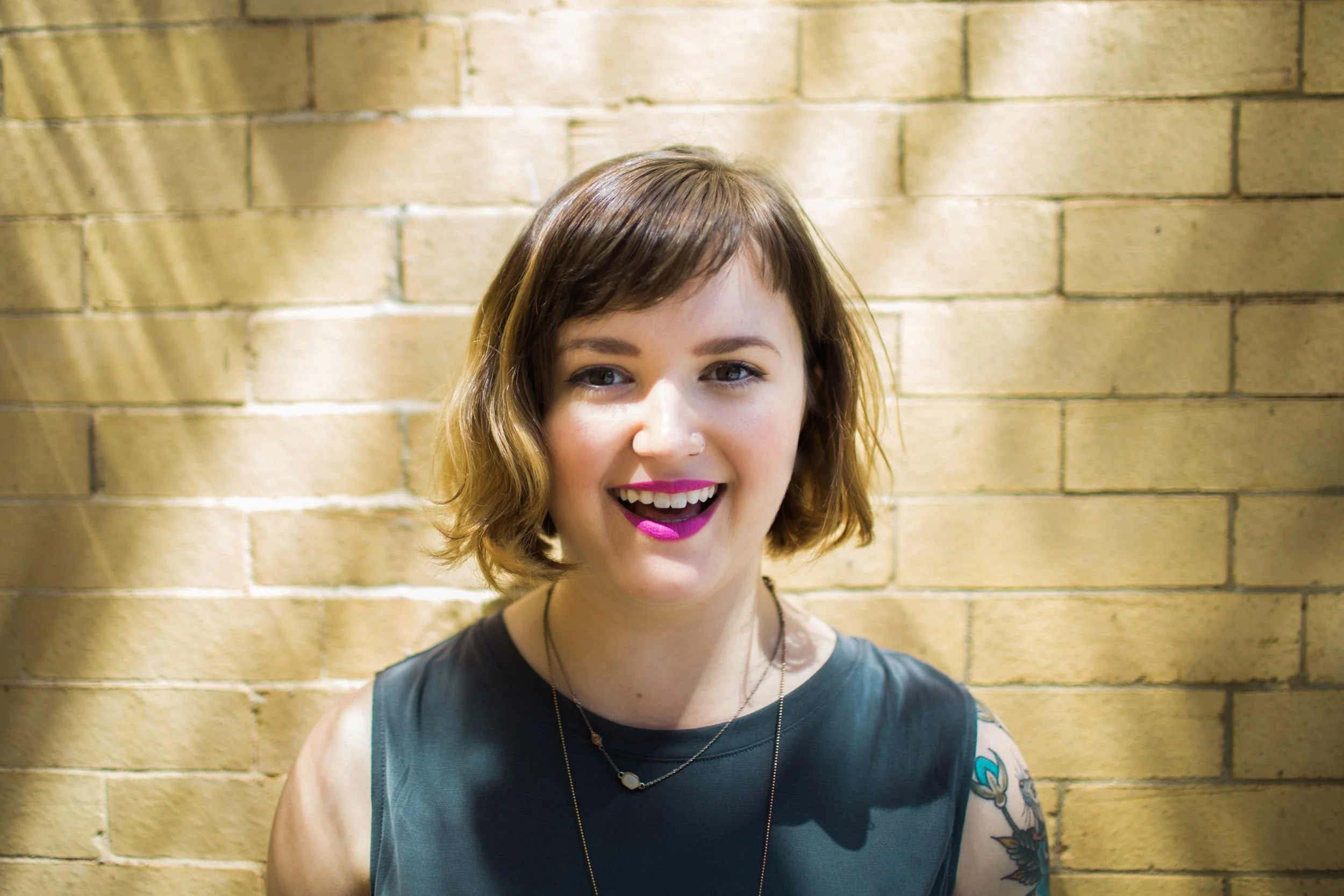 Portrait of a woman with a bob haircut and bright pink lipstick