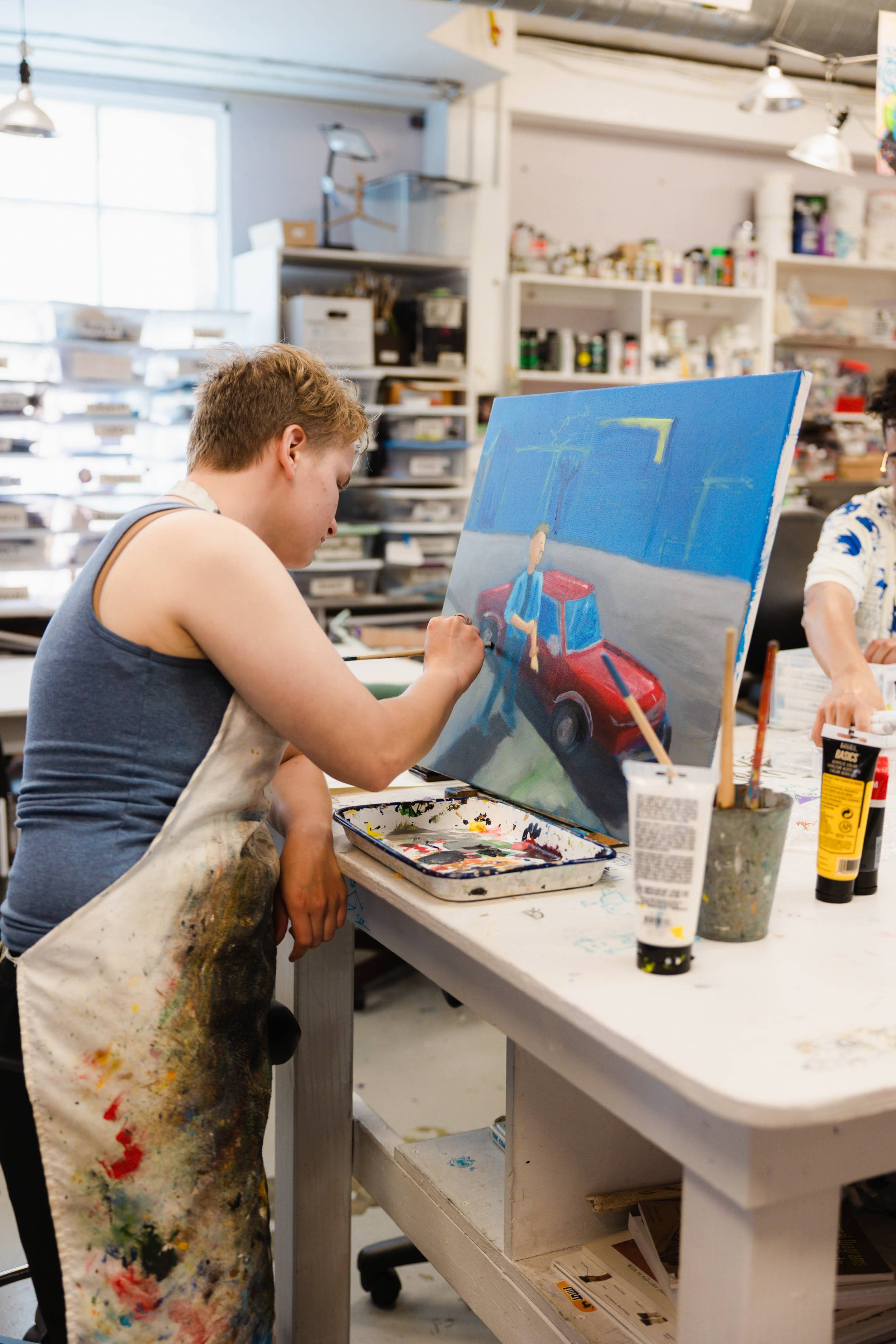 artist working - focus on piece at center, artist to the side