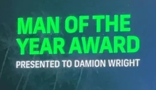 Green and white text announcing "Man of the Year Award" presented to Damion Wright.