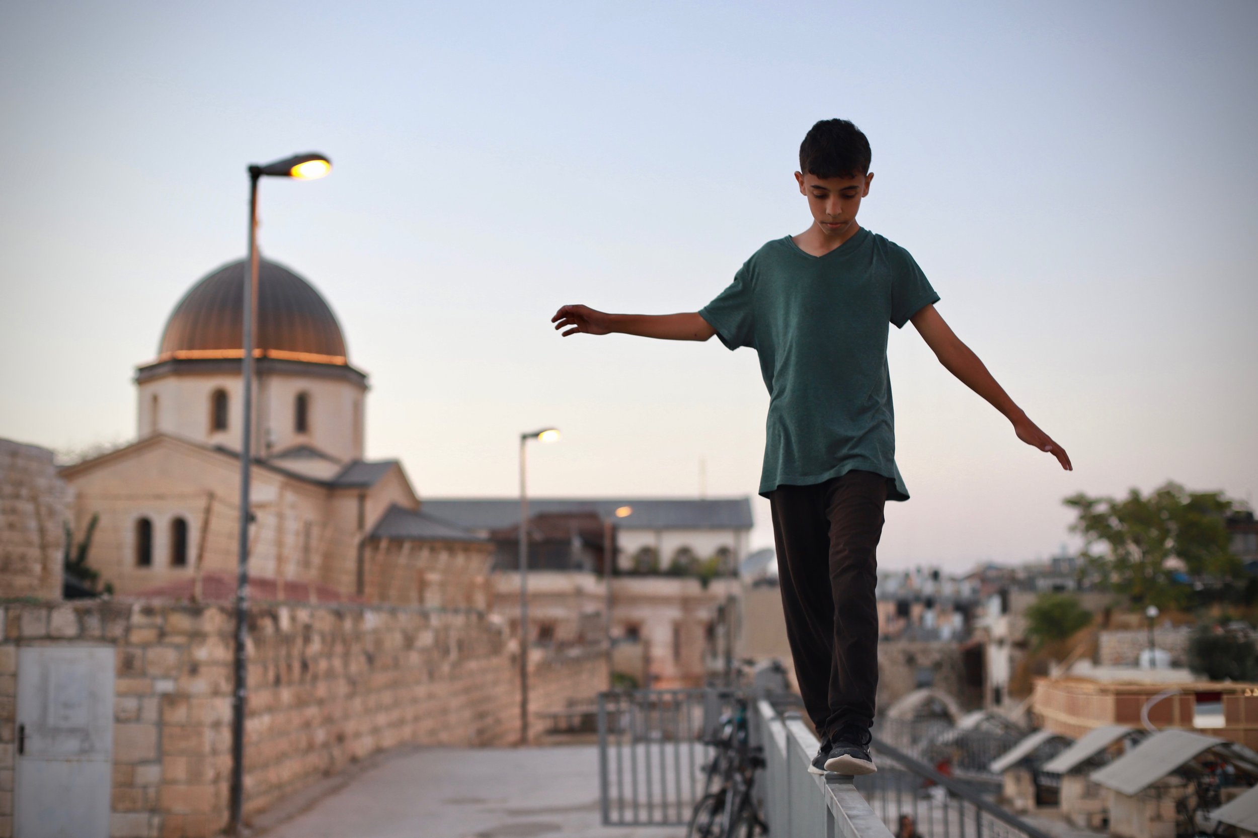 A young Palestinian parkour athlete practices on the rooftops of the Old City. Jerusalem, September 2021.