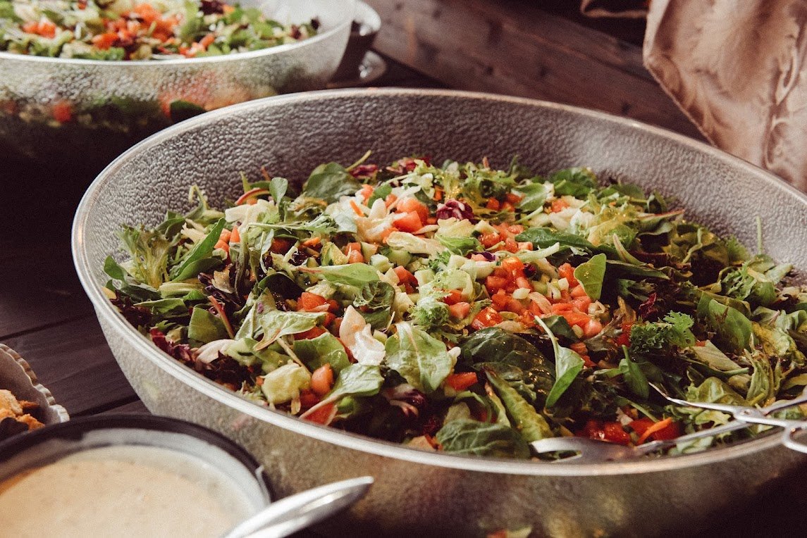 Fresh garden salad in large bowl with mixed greens, tomatoes, and vegetables