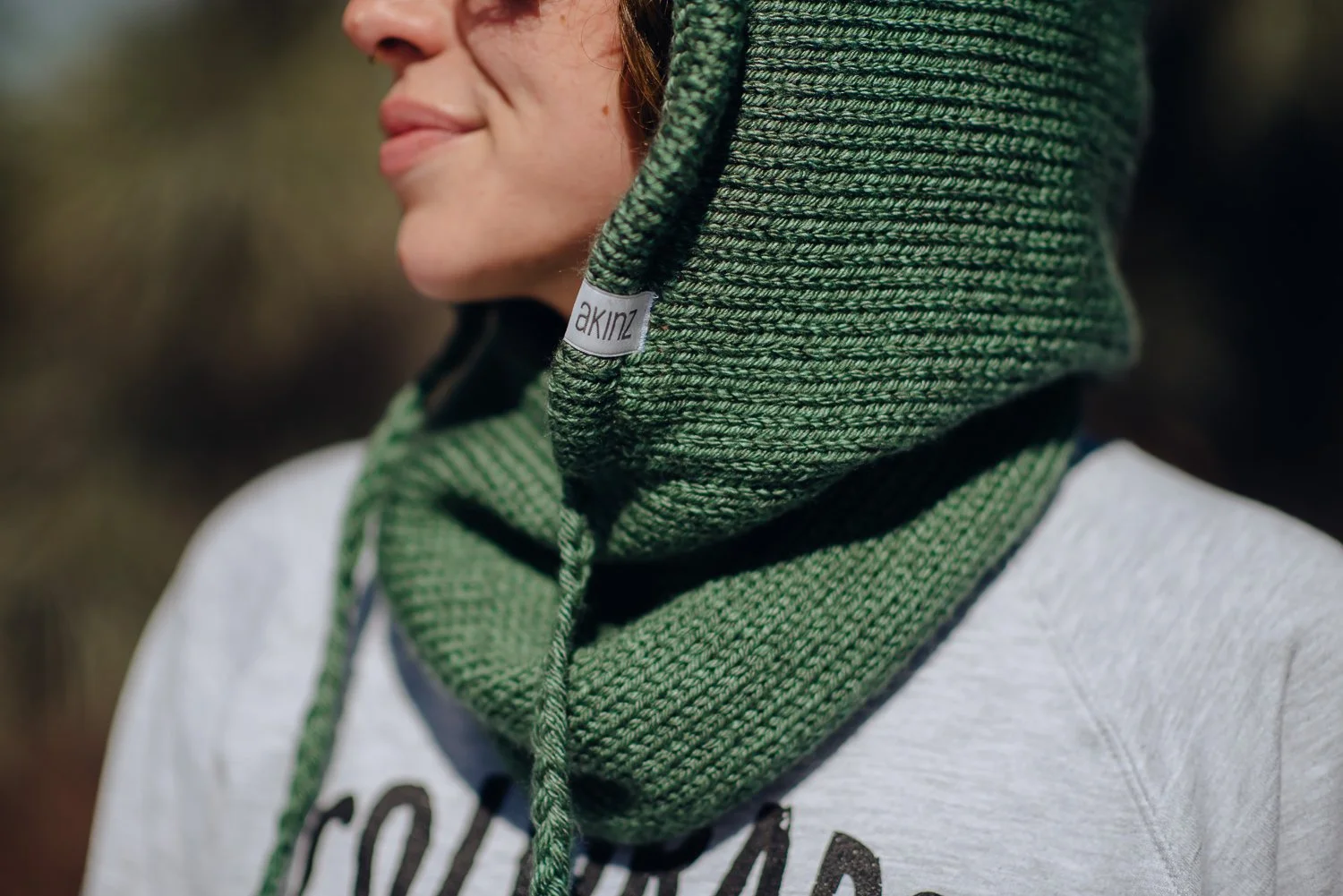 Professional lifestyle photography of young Puerto Rican model with short, curly, brown hair wearing Akinz Boardwear clothing in the snowy mountains in Colorado Springs, Colorado