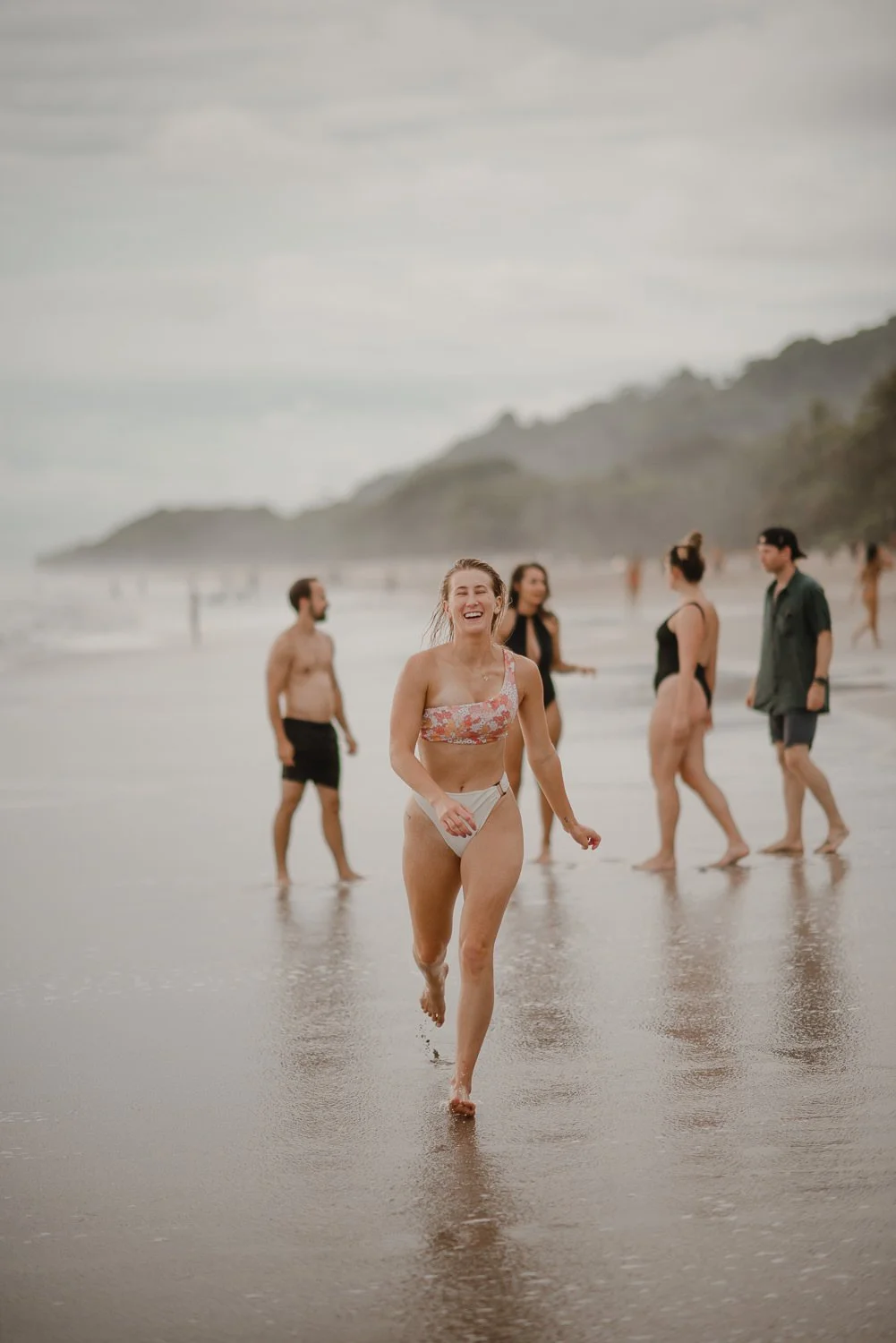 Cute girl smiles and runs toward the camera on the beach in Santa Teresa, Costa Rica. Travel Photographer