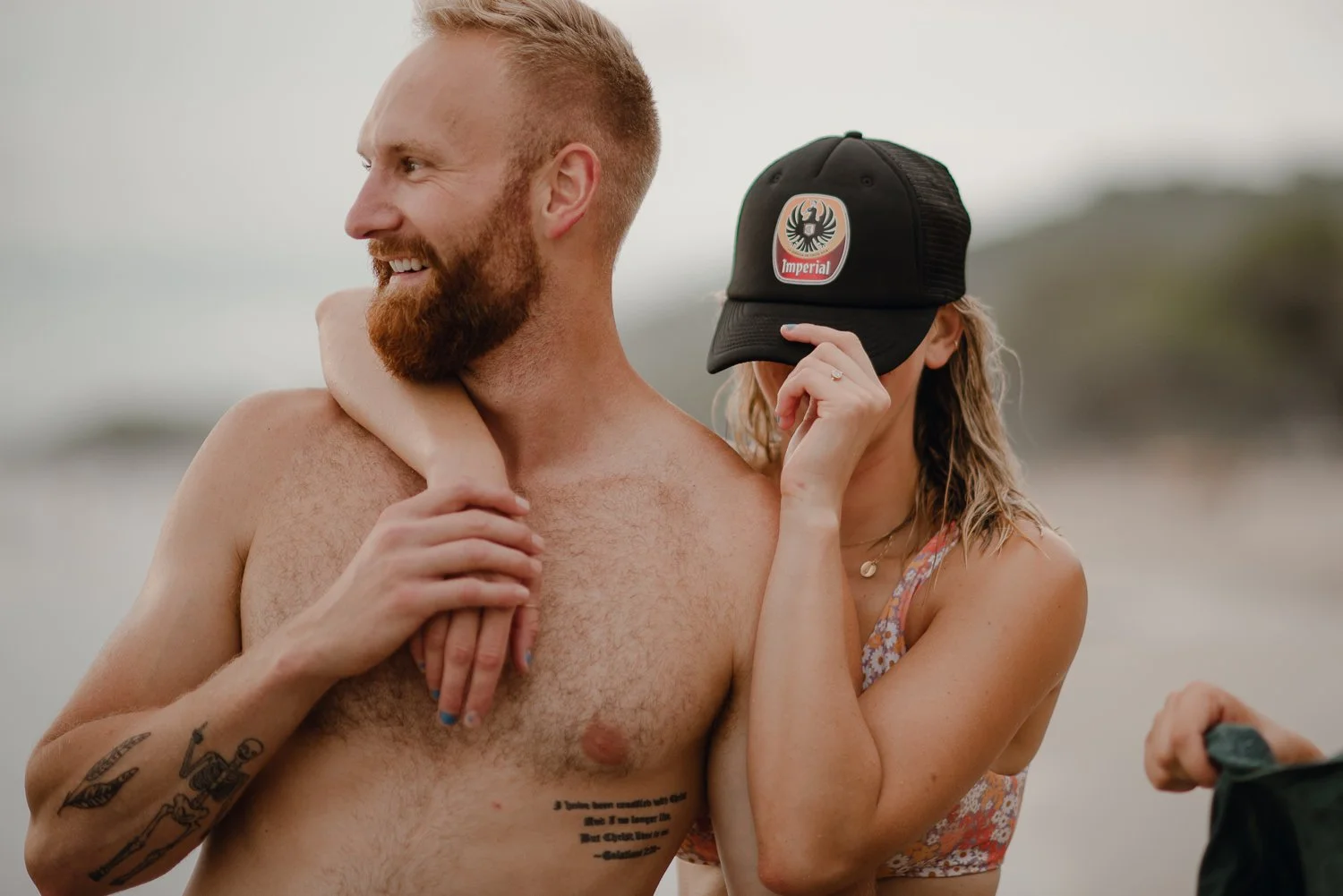 Travel photo of a cute girl hanging on her man at the beach in Costa Rica