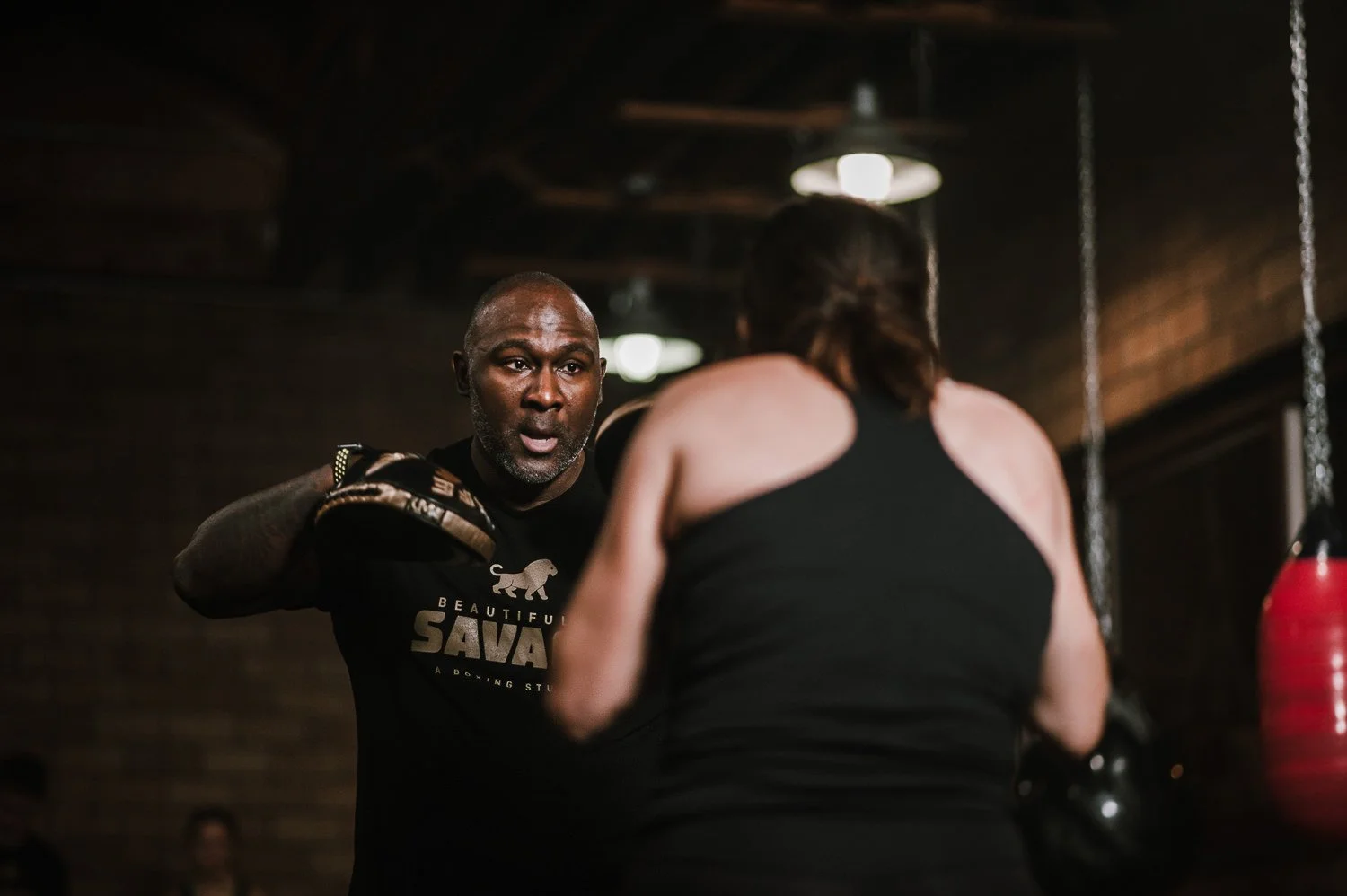 Lifestyle photograph of gym owner Joe Buckner training an athlete at Beautifully Savage boutique boxing gym in Fort Collins, Colorado