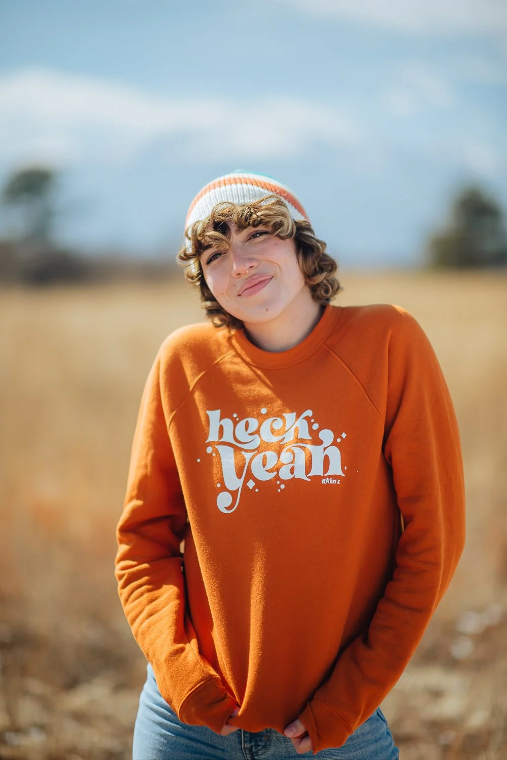 Lifestyle photography of a model wearing an orange crewneck sweater at Palmer Park in Colorado Springs, Colorado for Akinz Boardwear