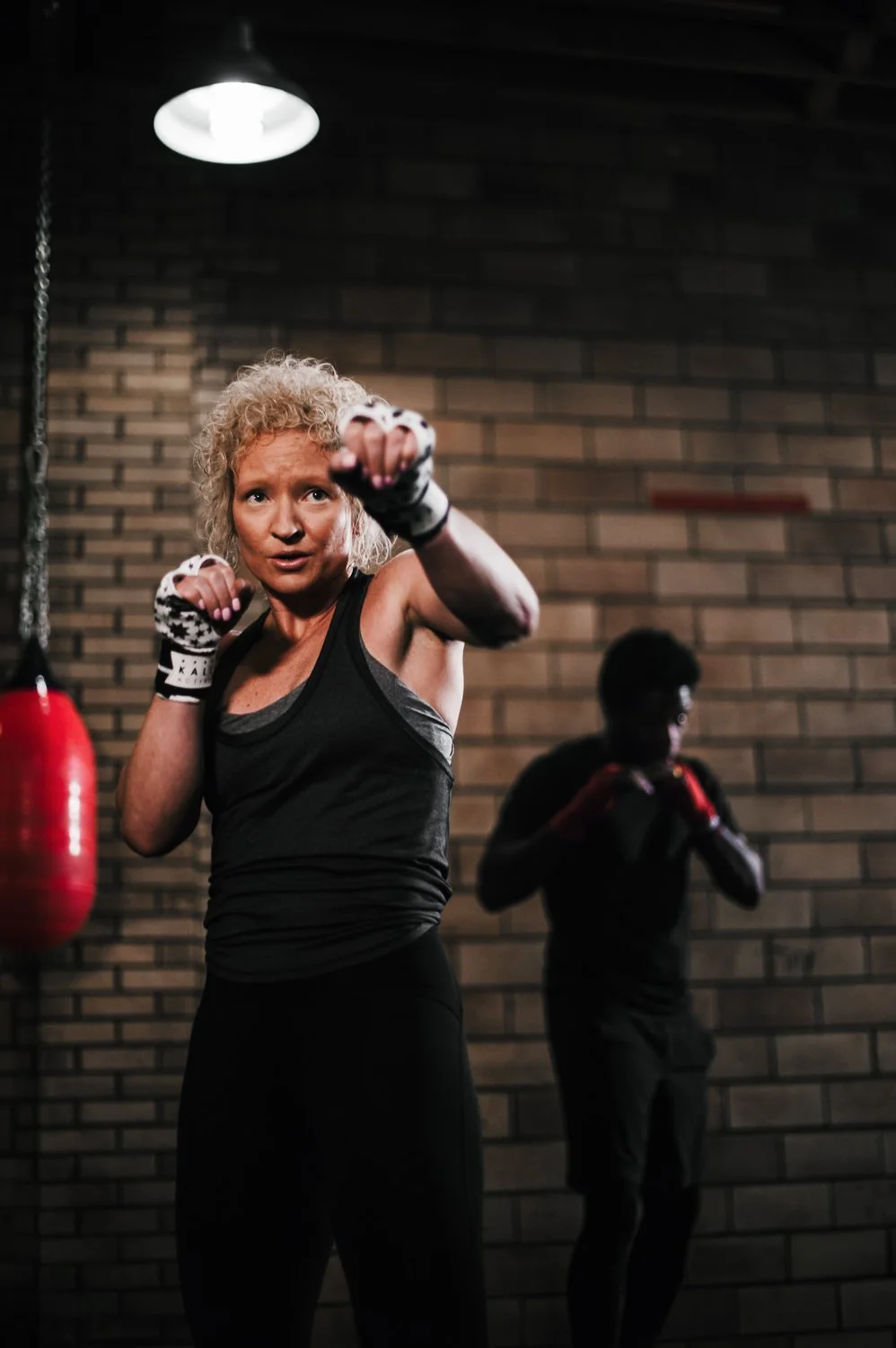 Lifestyle photograph of woman boxer wearing Kali Active hand wraps at Beautifully Savage boutique boxing gym in Fort Collins, Colorado