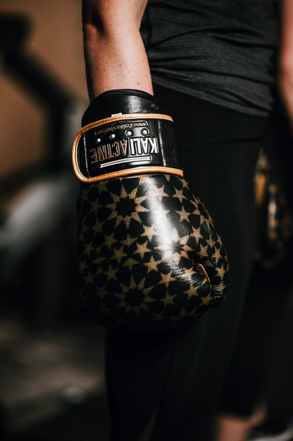 Lifestyle photograph of woman boxer wearing Kali Active boxing gloves at Beautifully Savage boutique boxing gym in Fort Collins, Colorado