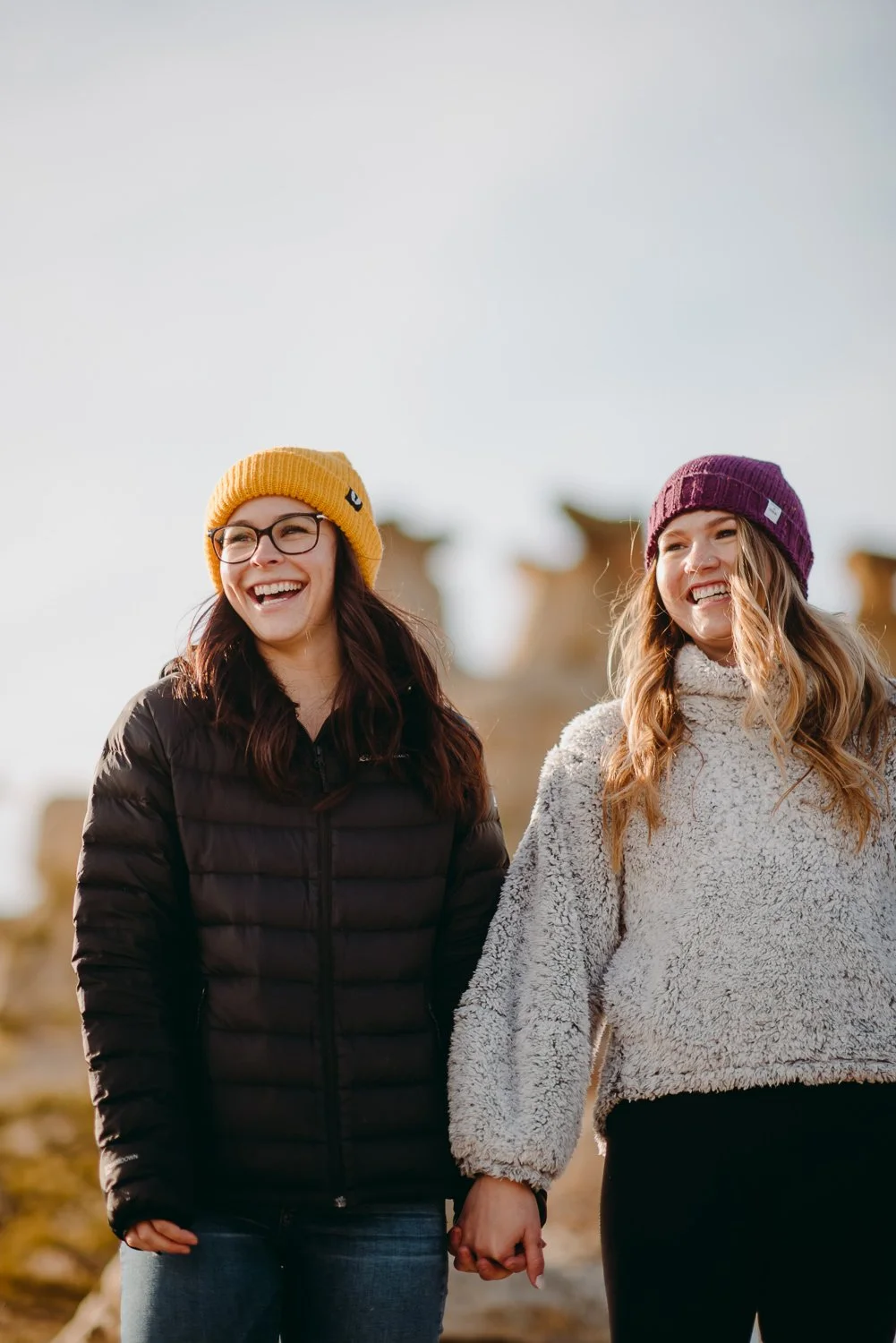 Lifestyle photography of young girls wearing a bright yellow beanie and purple beanie in Colorado Springs, Colorado for Akinz Boardwear