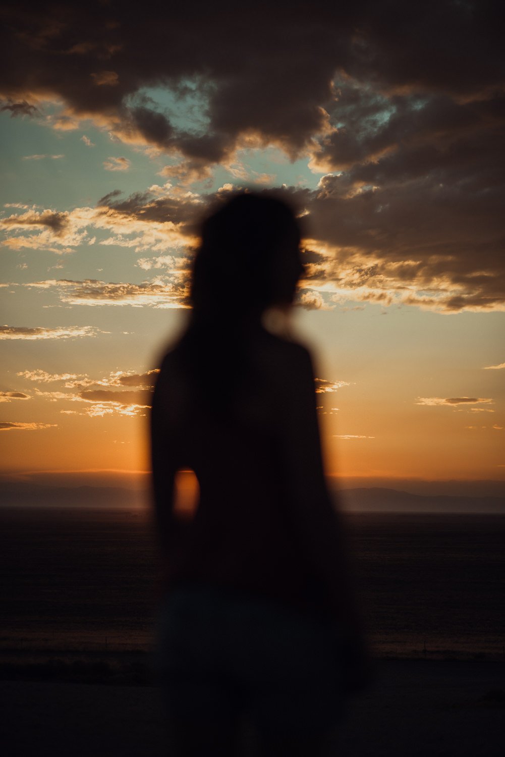 Adventure lifestyle photography of a girl's silhouette in front of the sunset near Great Sand Dunes National Park in Colorado