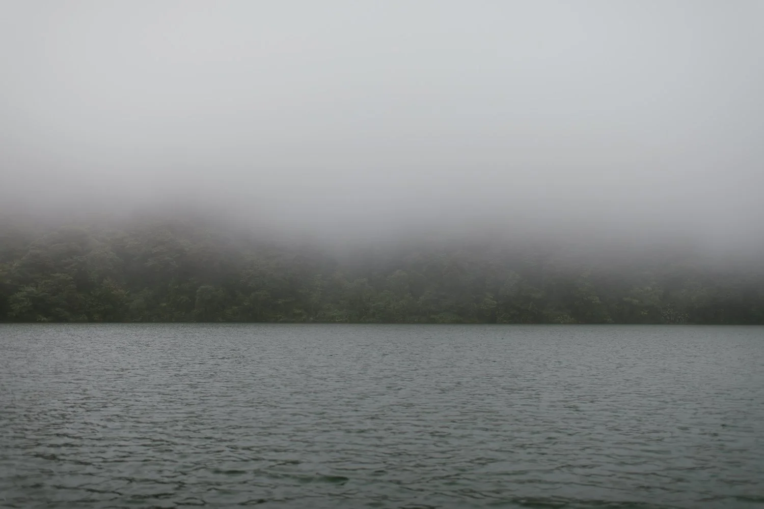 Landscape photograph of the foggy lake at the top of Cerro Chato in Costa Rica