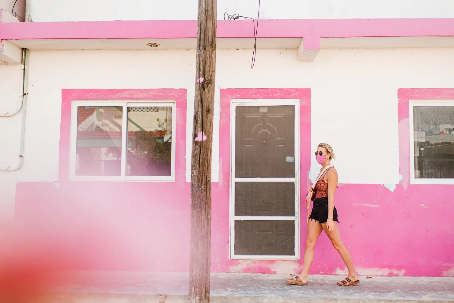 Professional product & branding photography for Sea'sons official face masks - lifestyle portrait with pink walls cute pink mask in Isla Holbox, Mexico.