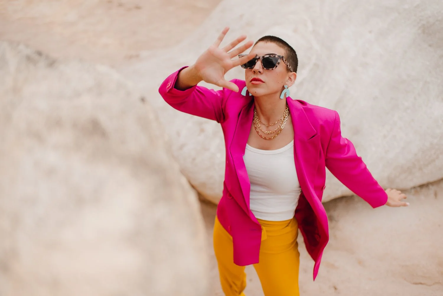 Professional editorial portrait photography at the Paint Mines Interpretive Park in Calhan, Colorado - colorful pink blazer, yellow pants