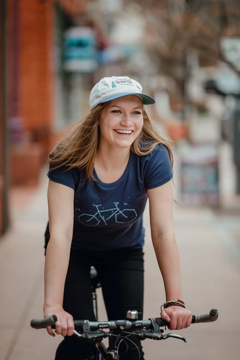 Lifestyle photography of a cute blonde girl riding a bike in Manitou Springs, Colorado for Akinz Boardwear
