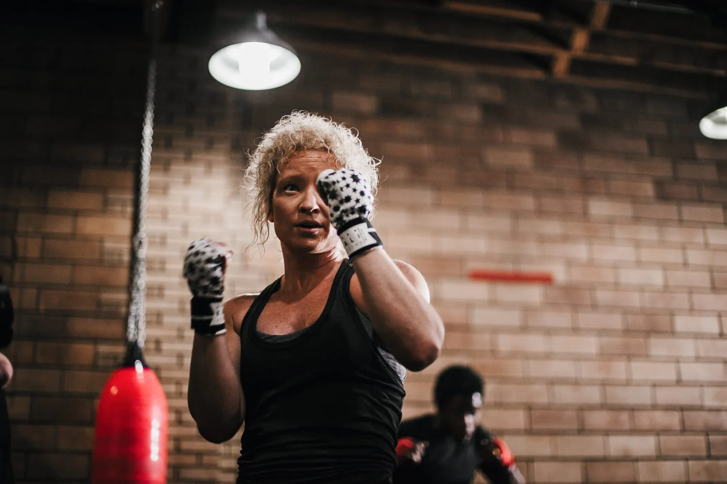 Lifestyle photograph of woman boxer wearing Kali Active hand wraps at Beautifully Savage boutique boxing gym in Fort Collins, Colorado