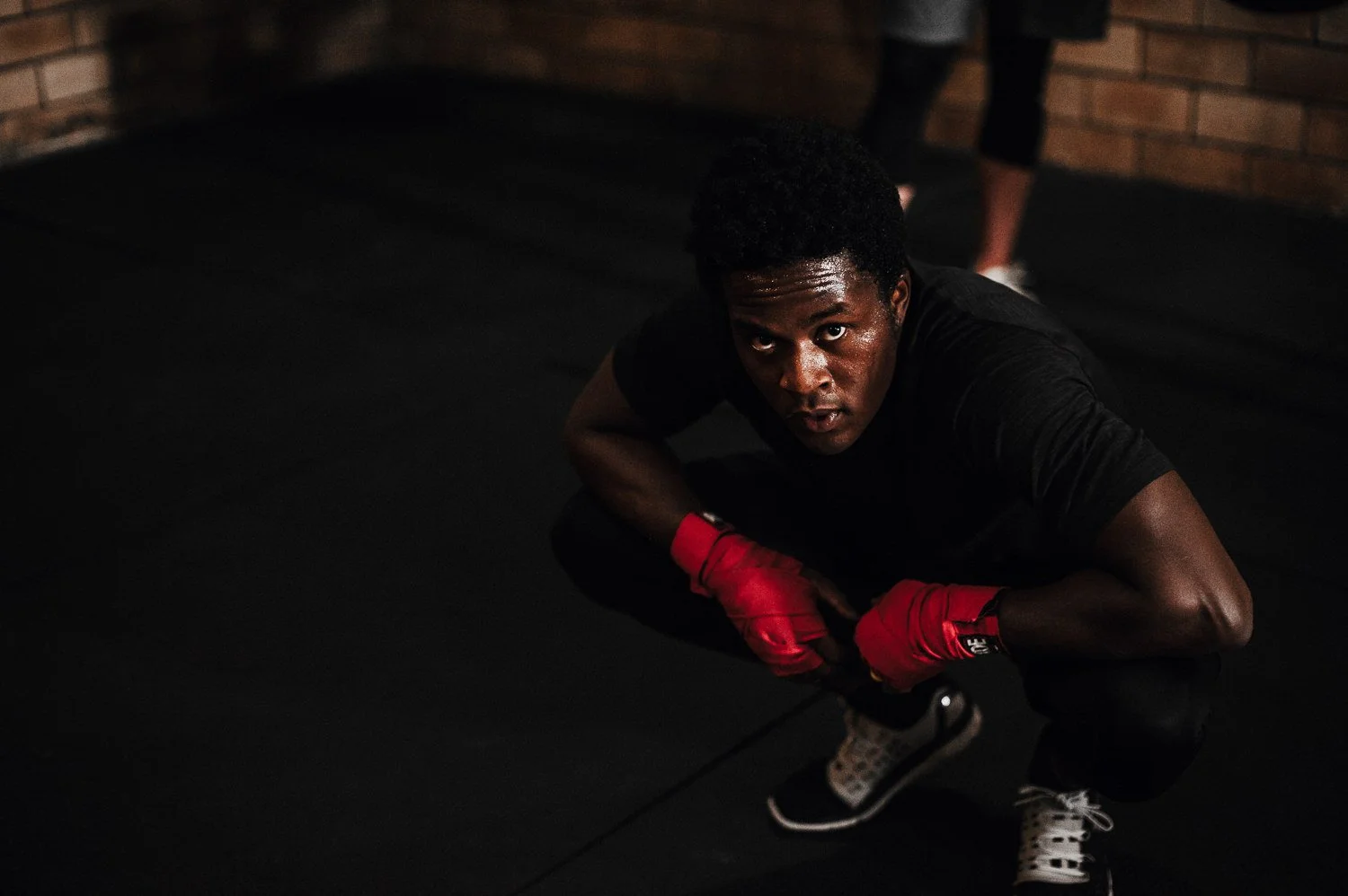 Lifestyle fitness portrait of a young healthy boxer resting at Beautifully Savage boutique boxing gym in Fort Collins, Colorado