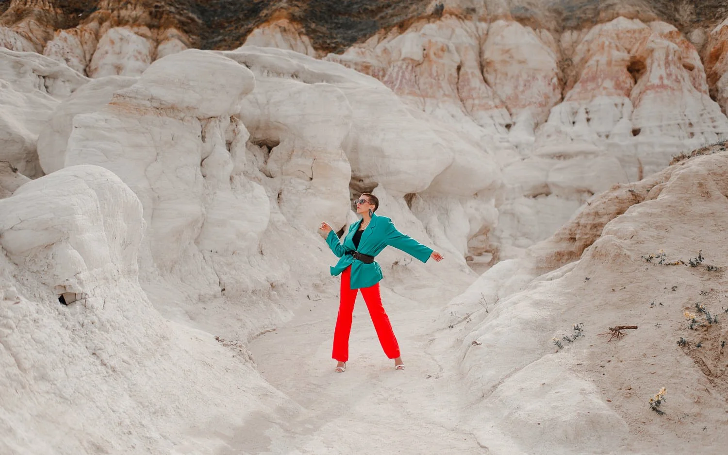 Professional editorial portrait photography at the Paint Mines Interpretive Park in Calhan, Colorado - colorful teal blazer, orange pants