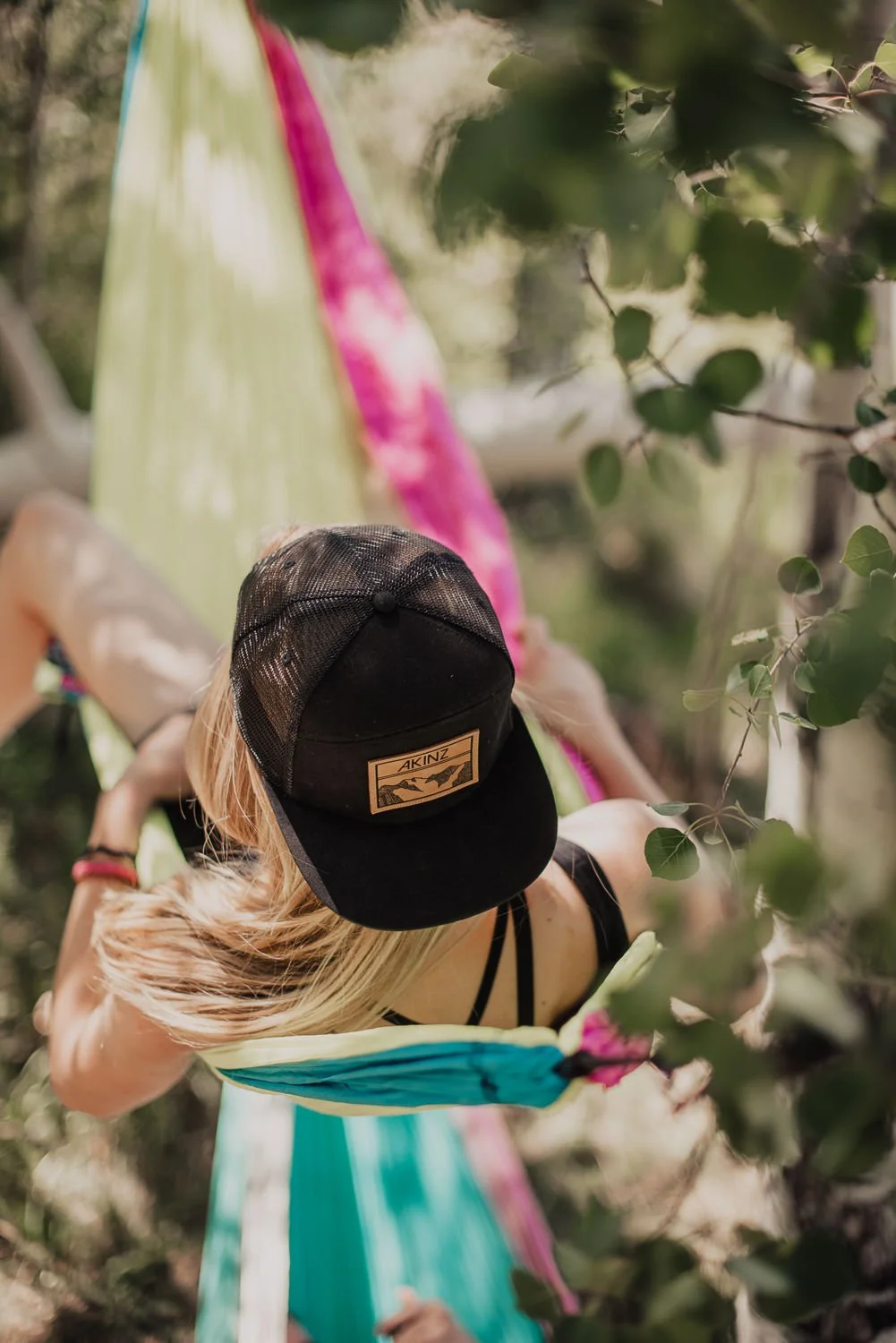 Lifestyle photography of two girls laying in a hammock, wearing Akinz Boardwear gear.