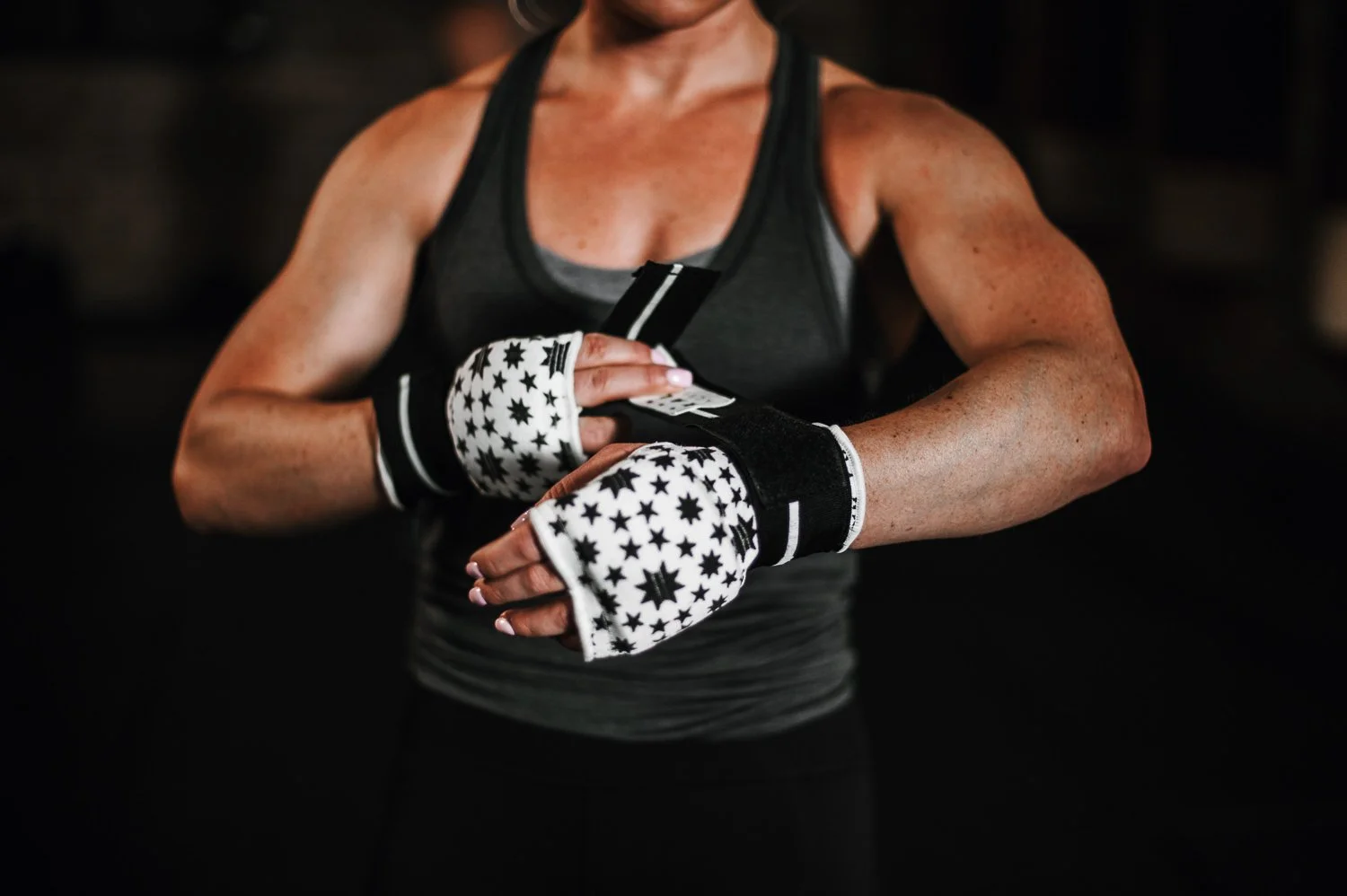 Lifestyle photograph of a woman wrapping her hands in Kali Active hand wraps at Beautifully Savage boutique boxing gym in Fort Collins, Colorado