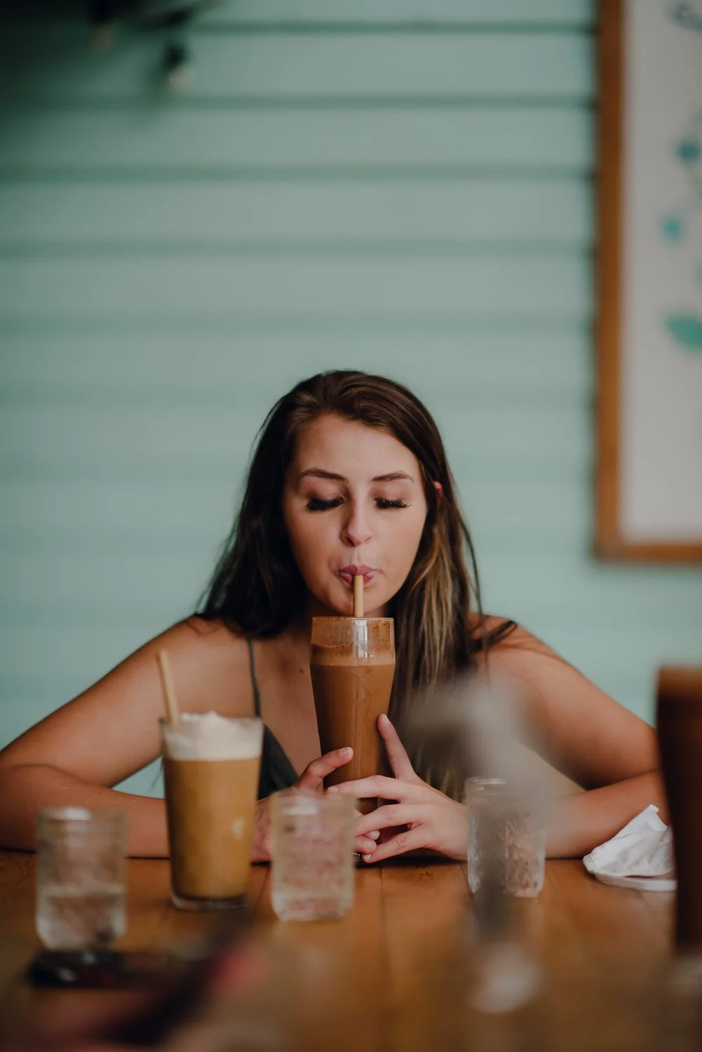 Lifestyle portrait of a girl drinking a healthy vegan milkshake at a bar in Costa Rica