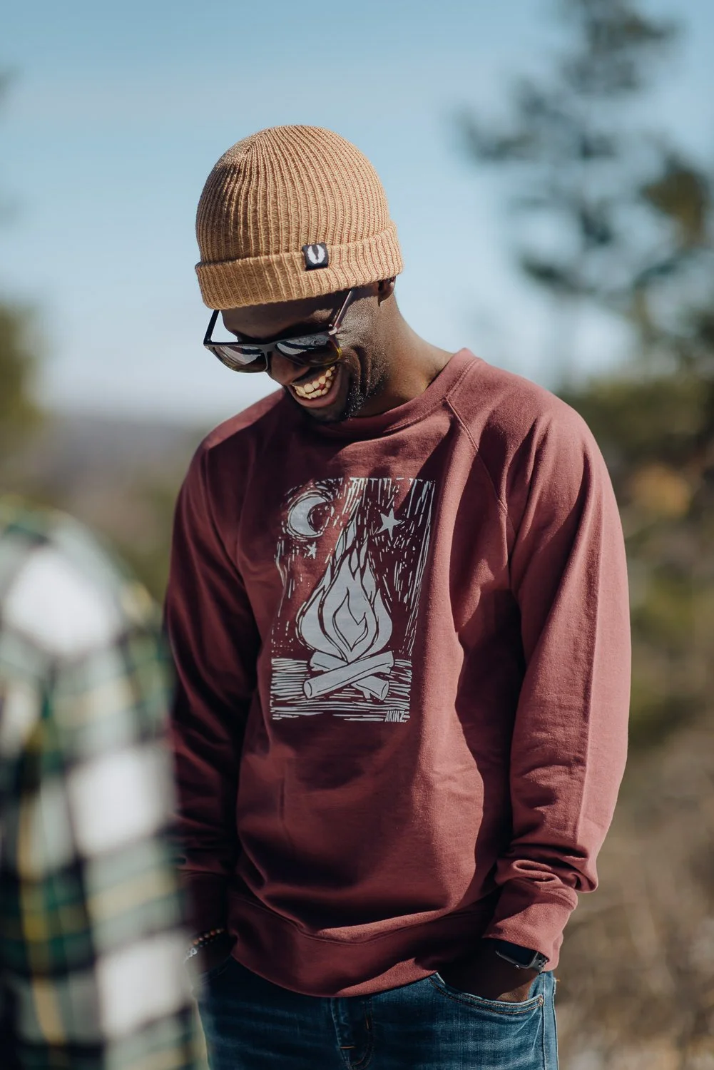 Professional lifestyle photography of young male model wearing a tan Akinz Boardwear beanie and red long sleeve tshirt in the snowy mountains in Colorado Springs, Colorado