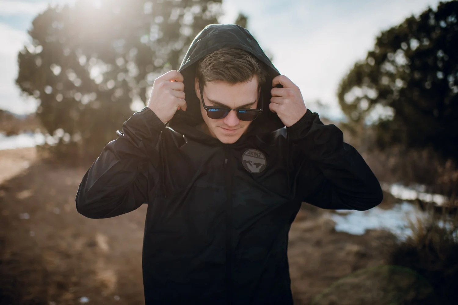 Lifestyle photography of young guy wearing a black windbreaker in Colorado Springs, Colorado for Akinz Boardwear