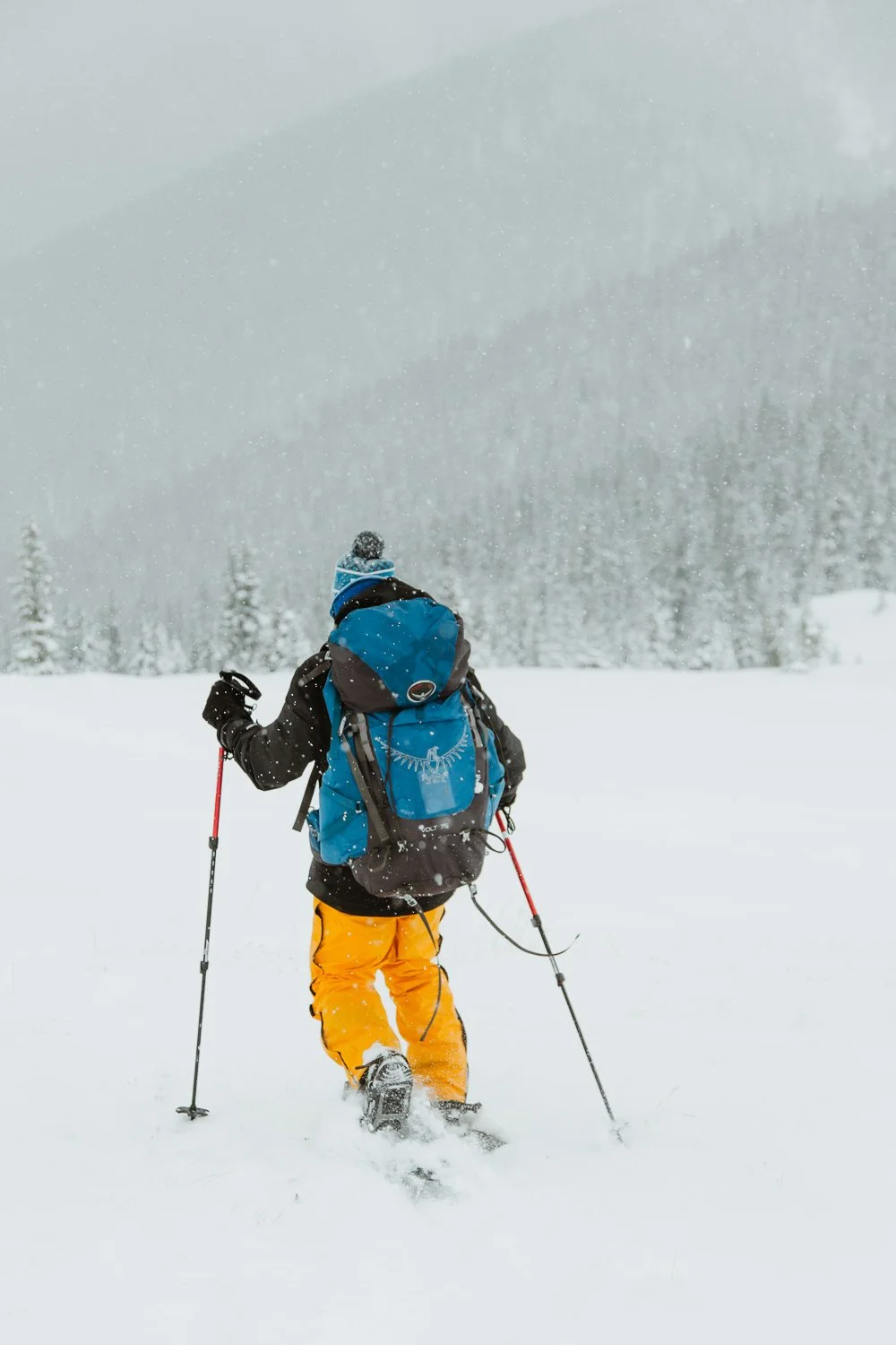 Adventure photography or hiker wearing yellow snow pants near Breckenridge, Colorado - snowshoeing winter hut trip
