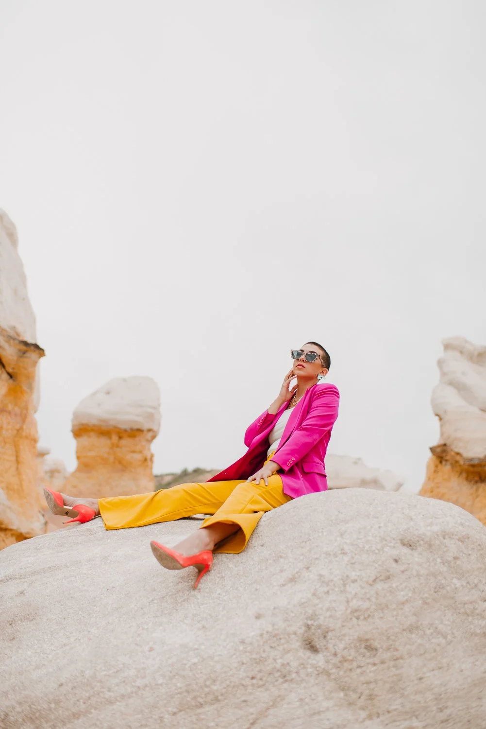 Professional editorial portrait photography at the Paint Mines Interpretive Park in Calhan, Colorado - colorful pink blazer, yellow pants