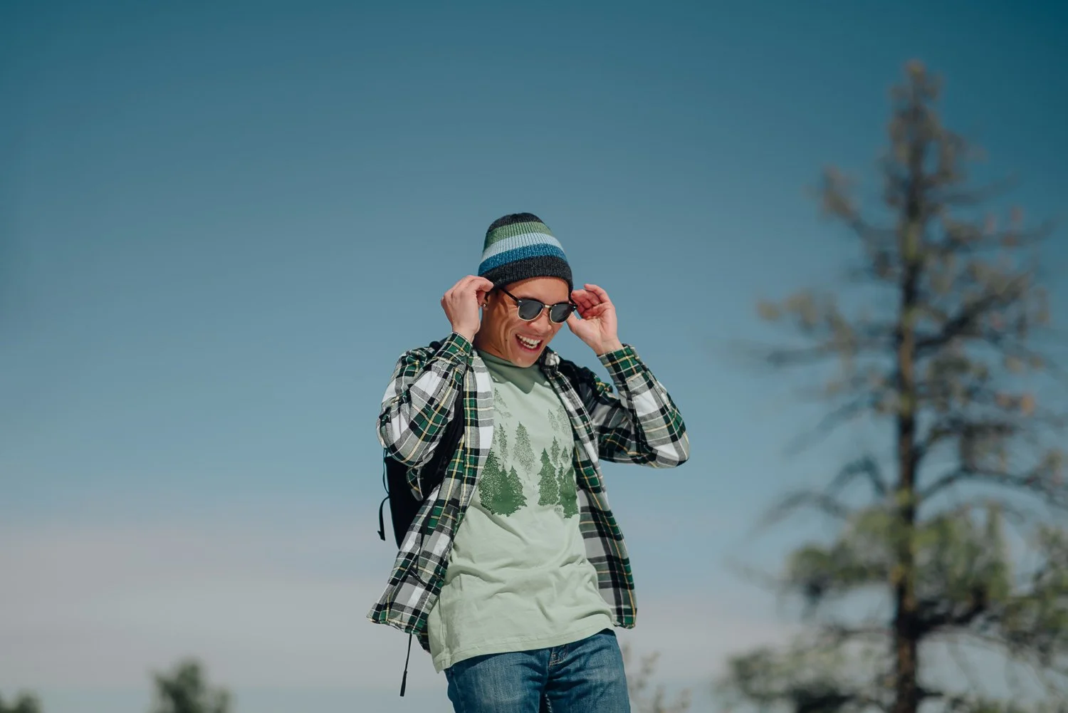 Professional lifestyle photography of young male model wearing an Akinz Boardwear beanie and light green tshirt in the snowy mountains in Colorado Springs, Colorado