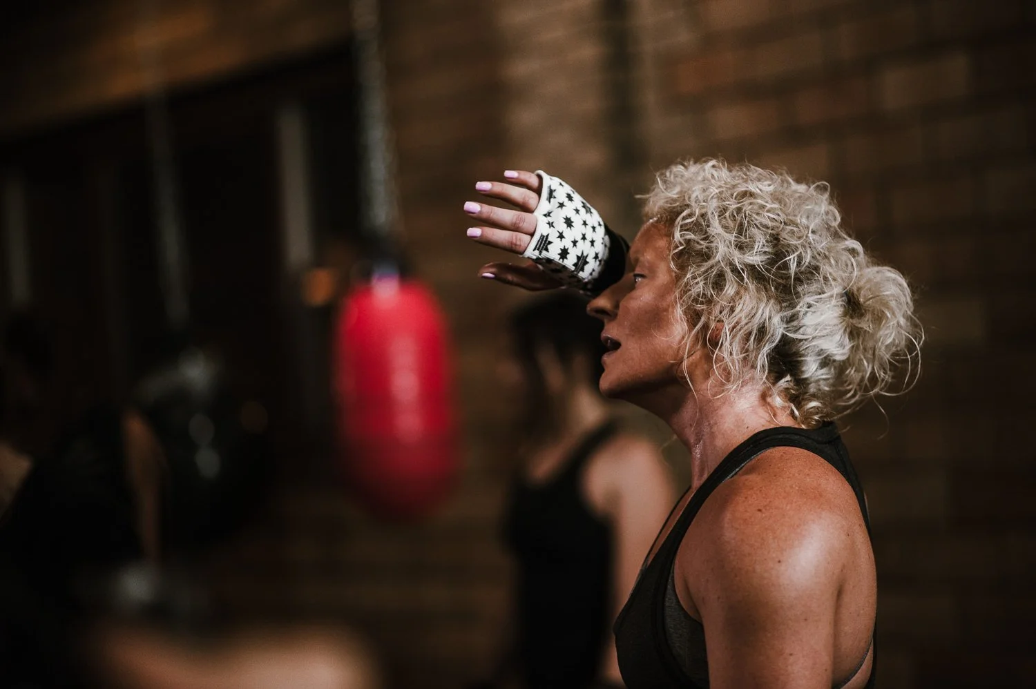 Lifestyle photograph of woman boxer wearing Kali Active hand wraps at Beautifully Savage boutique boxing gym in Fort Collins, Colorado