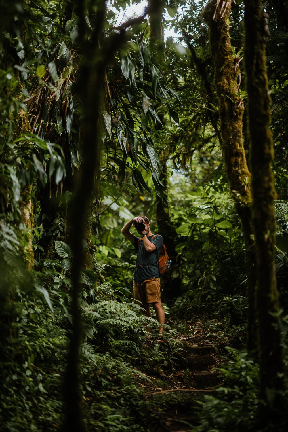 travel photograph of a young photographer exploring on a trail in Monteverde cloud forest in Costa Rica