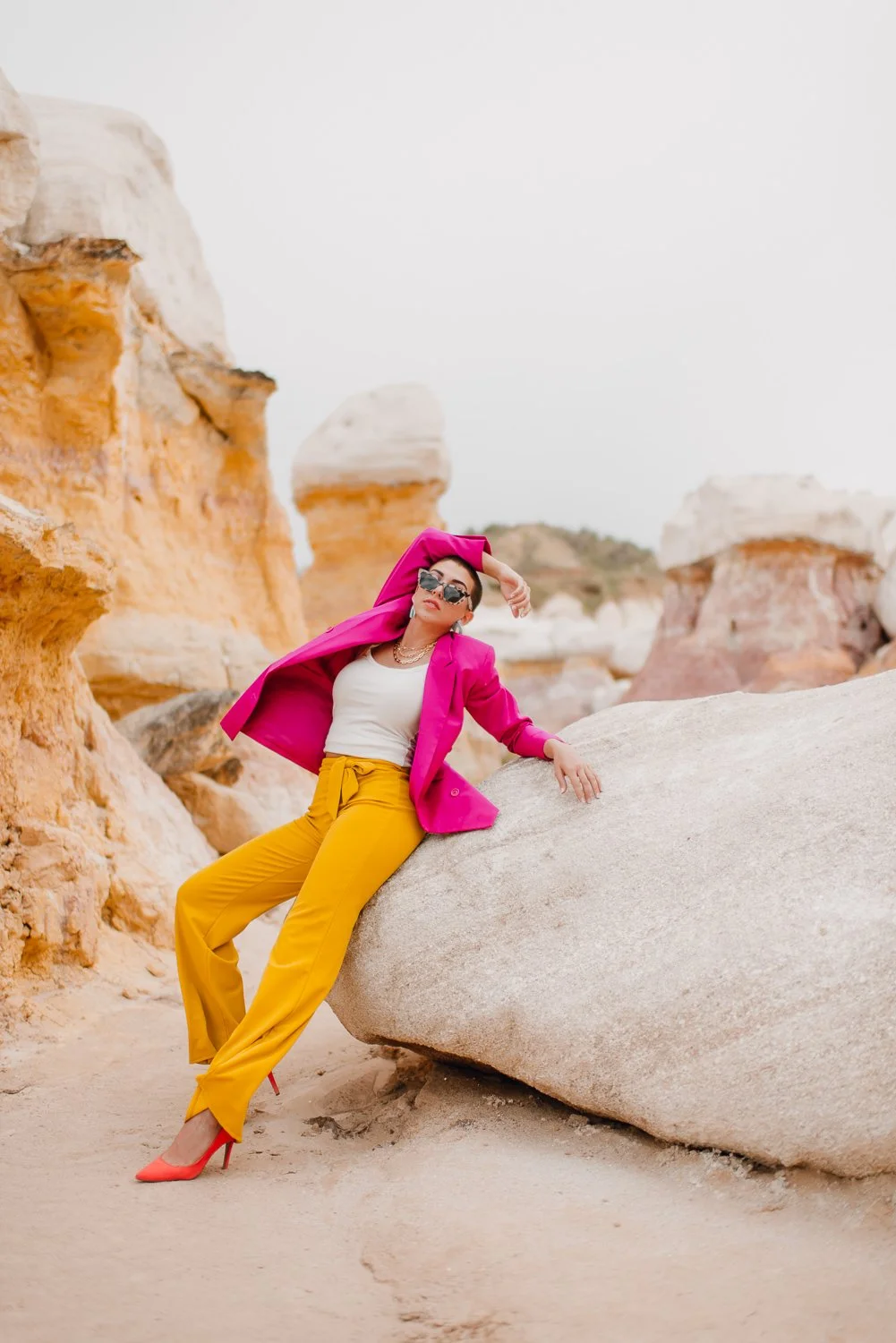 Professional editorial portrait photography at the Paint Mines Interpretive Park in Calhan, Colorado - colorful pink blazer, yellow pants