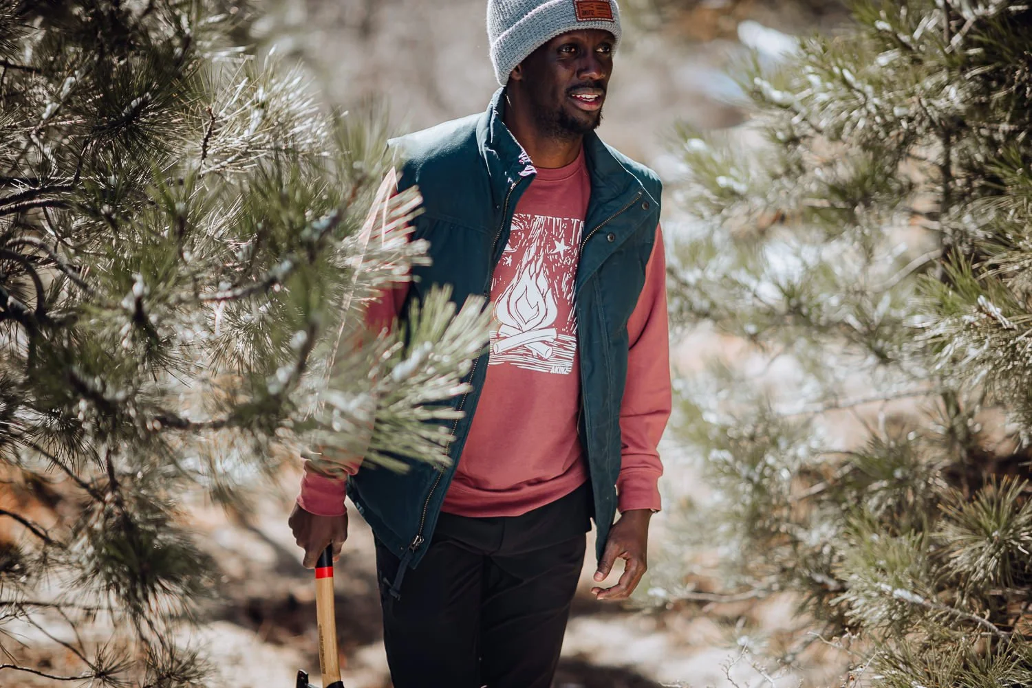 Lifestyle photography of a model wearing an gray beanie and light red graphic shirt at Palmer Park in Colorado Springs, Colorado for Akinz Boardwear
