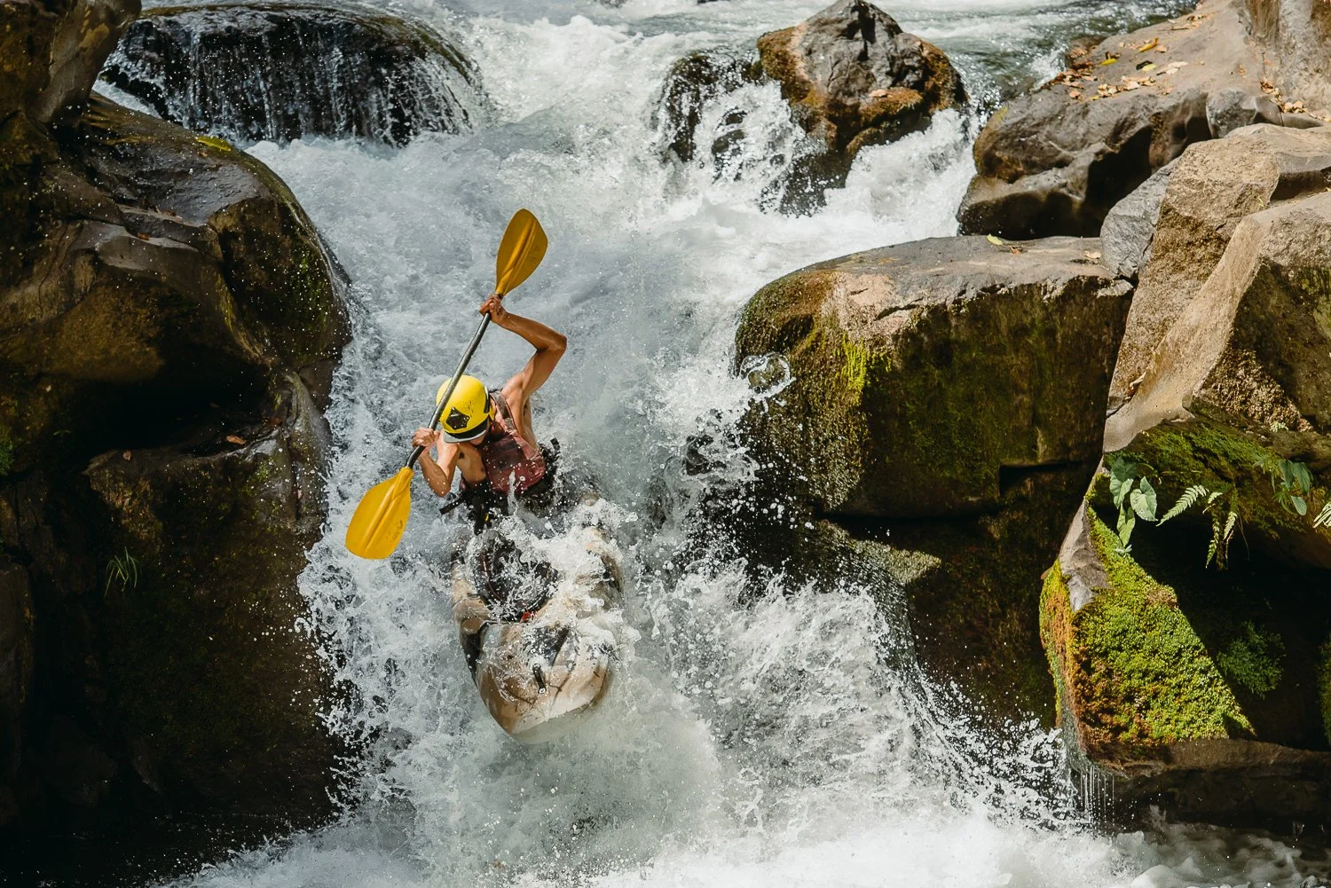 Travel photograph of a young man kayaking down a river in Costa Rica