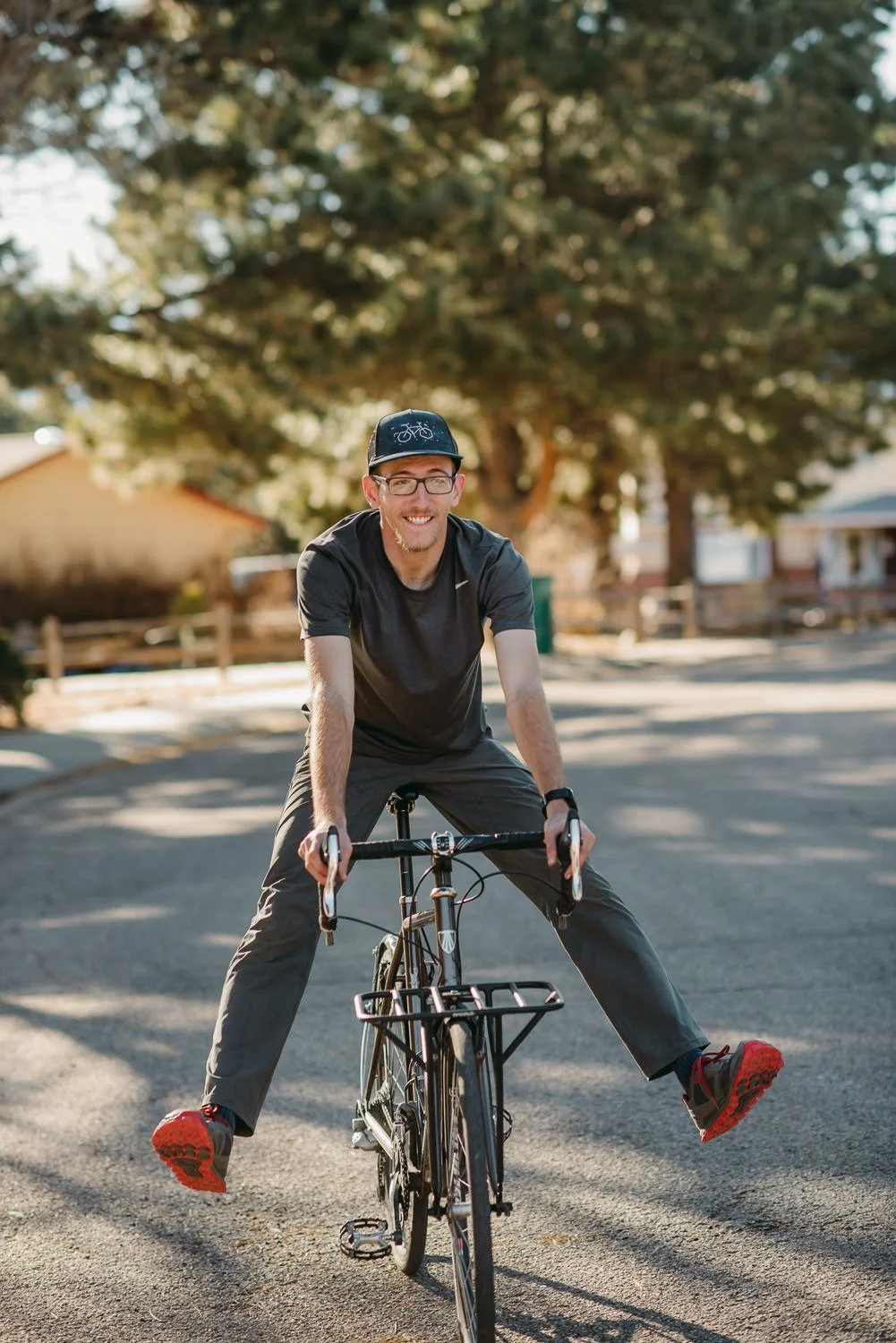 Lifestyle photography of a guy fooling around while riding a bike in Colorado Springs, CO for Akinz Boardwear