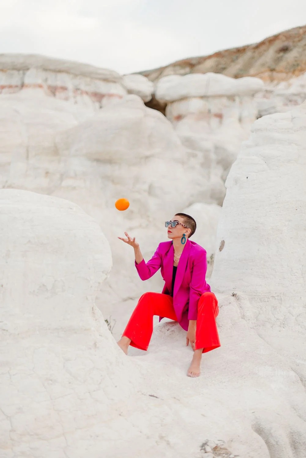 Professional editorial portrait photography at the Paint Mines Interpretive Park in Calhan, Colorado - colorful pink blazer, orange pants