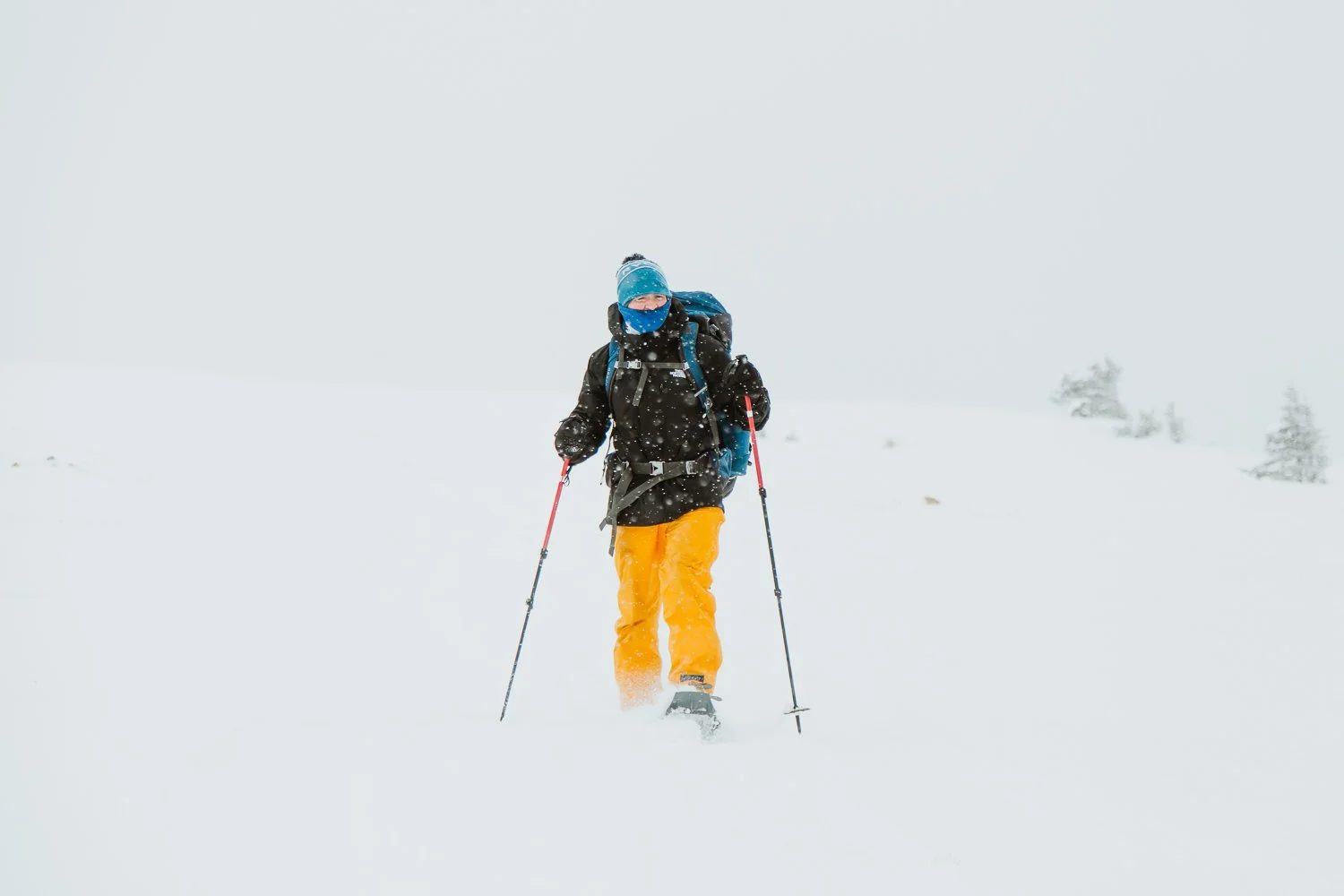 Adventure photography or hiker wearing yellow snow pants near Breckenridge, Colorado - snowshoeing winter hut trip