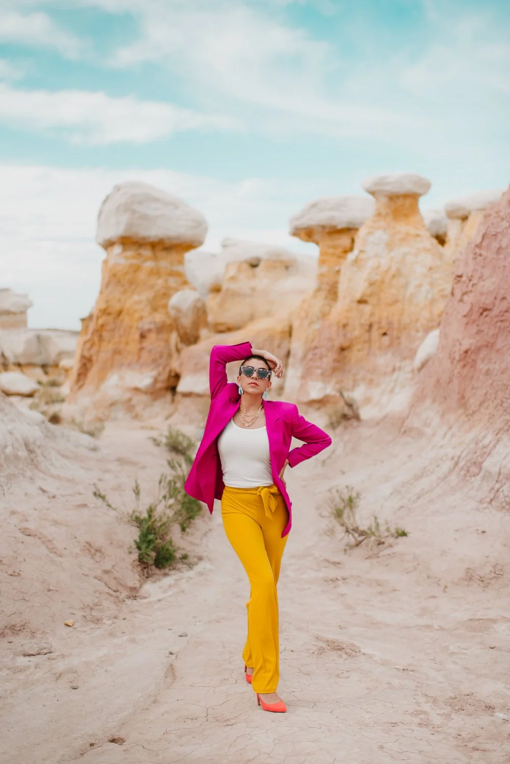 Professional editorial portrait photography at the Paint Mines Interpretive Park in Calhan, Colorado - colorful pink blazer, yellow pants