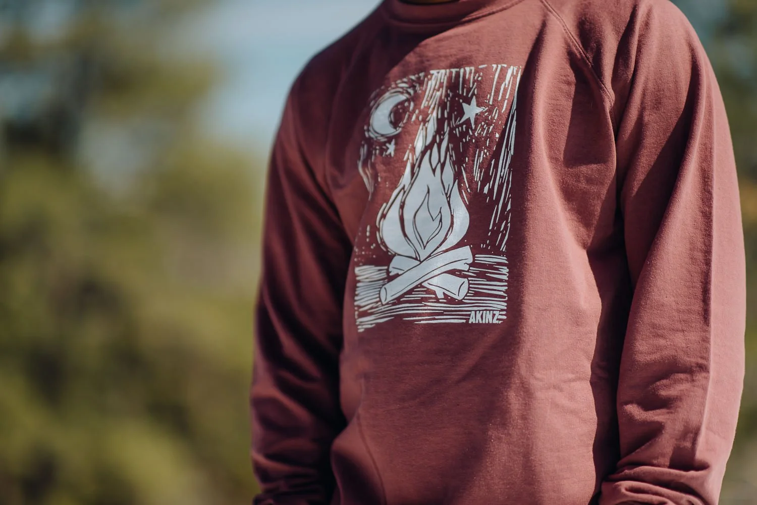 Professional lifestyle photography of young male model wearing a Akinz Boardwear red long sleeve tshirt in the snowy mountains in Colorado Springs, Colorado