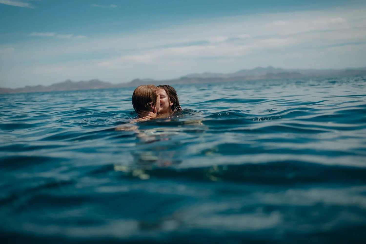 Ryan-Waneka-Photography-2022-La-Paz-Mexico-24-couple-kisses-in-ocean.jpg