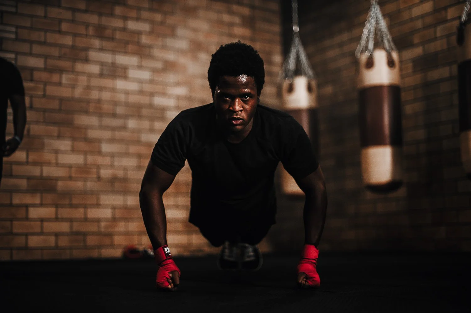 Fitness photograph of a young man doing pushups in Beautifully Savage boutique boxing gym in Fort Collins, Colorado