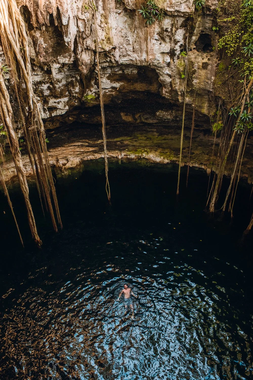 Professional travel photography in Tulum, Mexico - Best cenotes in Tulum, man swimming in Cenote Oxman