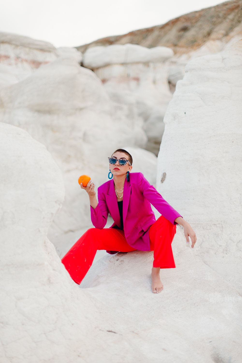 Professional editorial portrait photography at the Paint Mines Interpretive Park in Calhan, Colorado - colorful pink blazer, orange pants