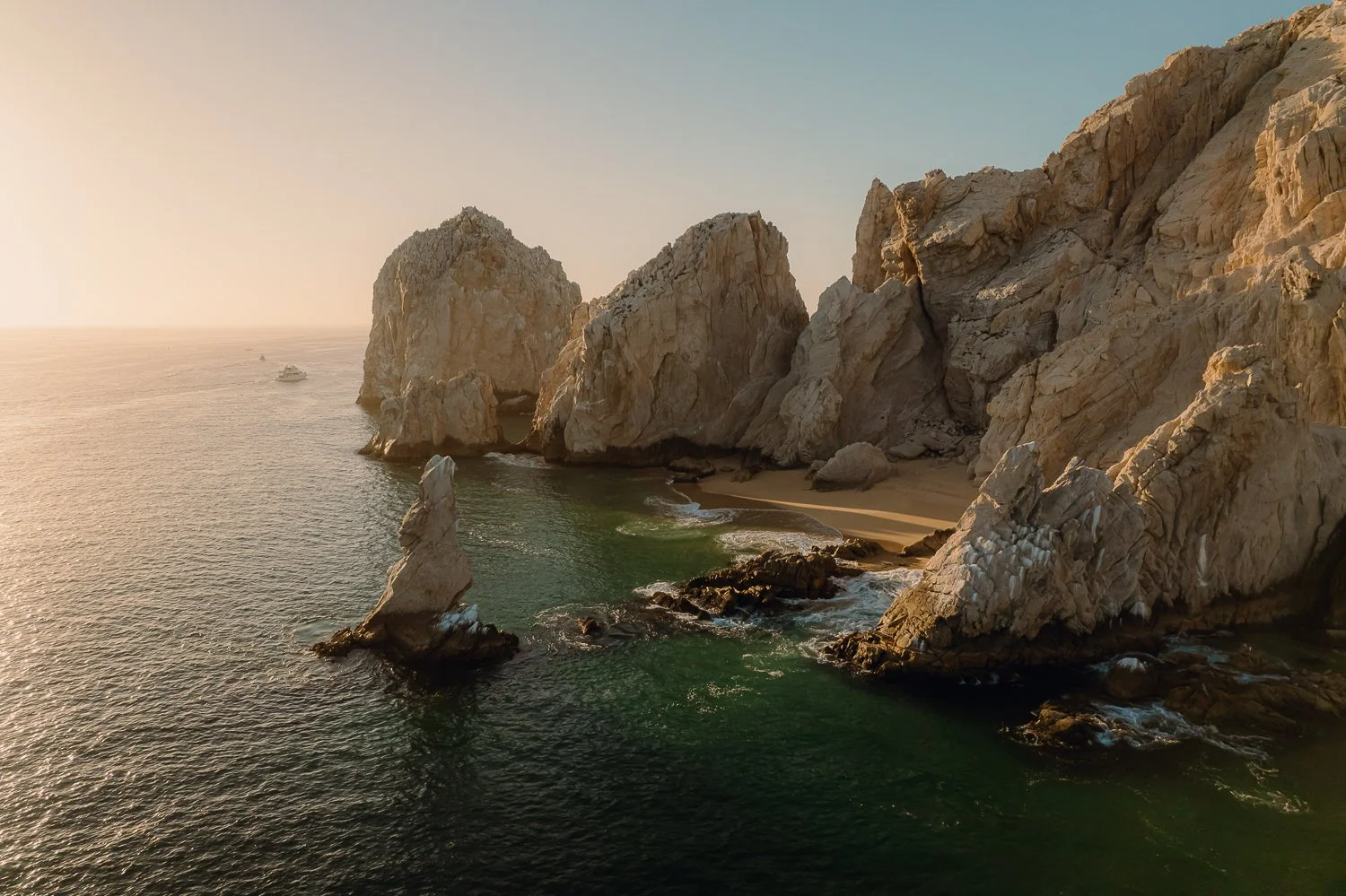 Travel drone photography of the rock formations during sunrise at Lover's Beach in Cabo San Lucas, Mexico