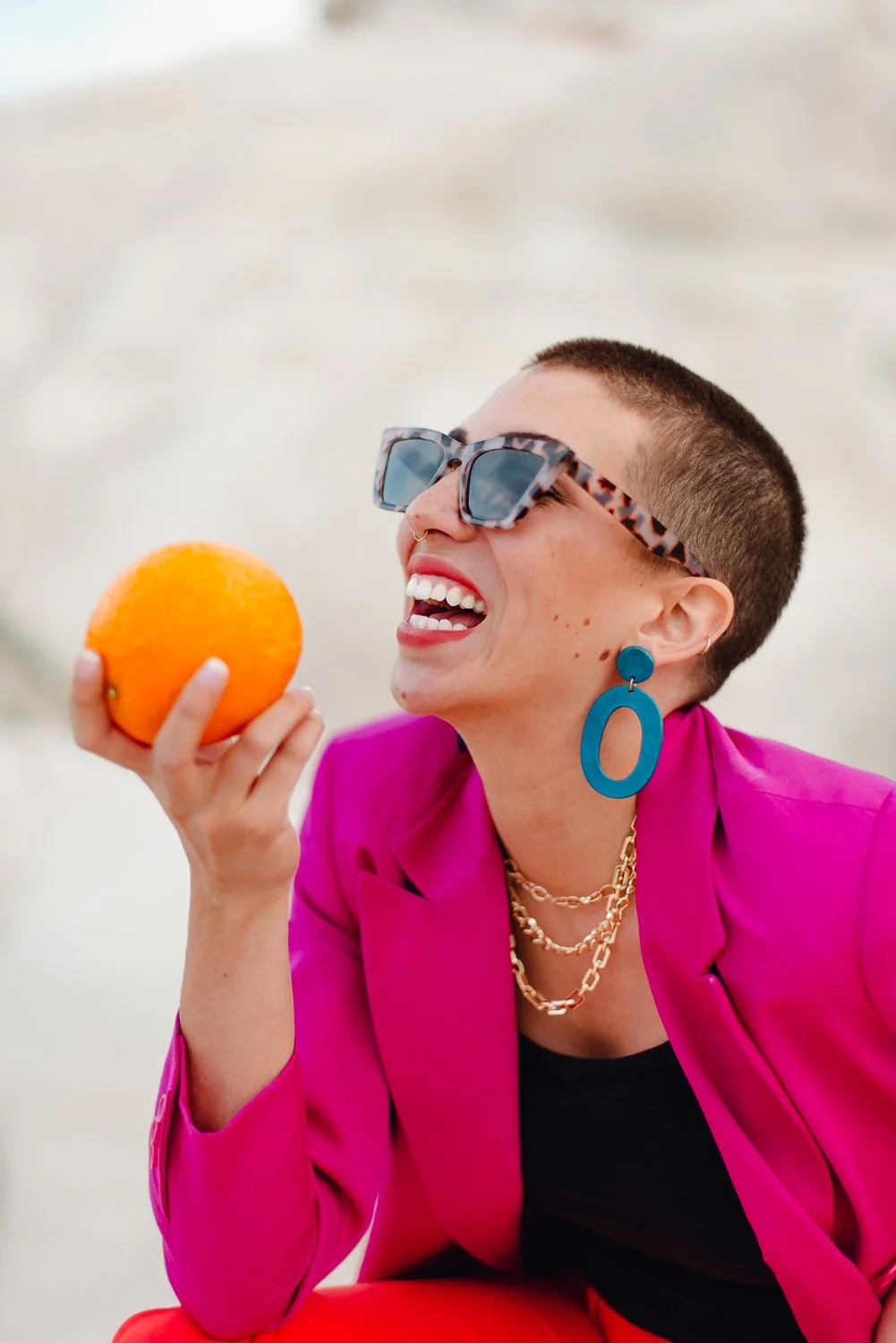 Professional editorial portrait photography at the Paint Mines Interpretive Park in Calhan, Colorado - colorful pink blazer, orange pants