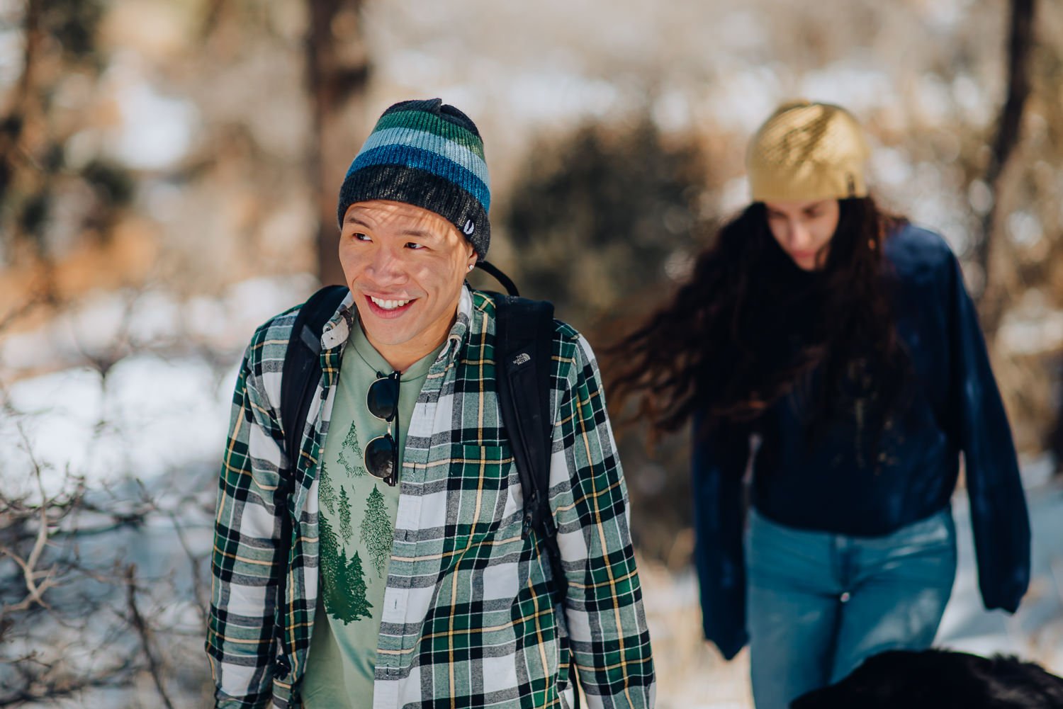 Professional lifestyle photography of young male model wearing an Akinz Boardwear beanie and light green tshirt in the snowy mountains in Colorado Springs, Colorado