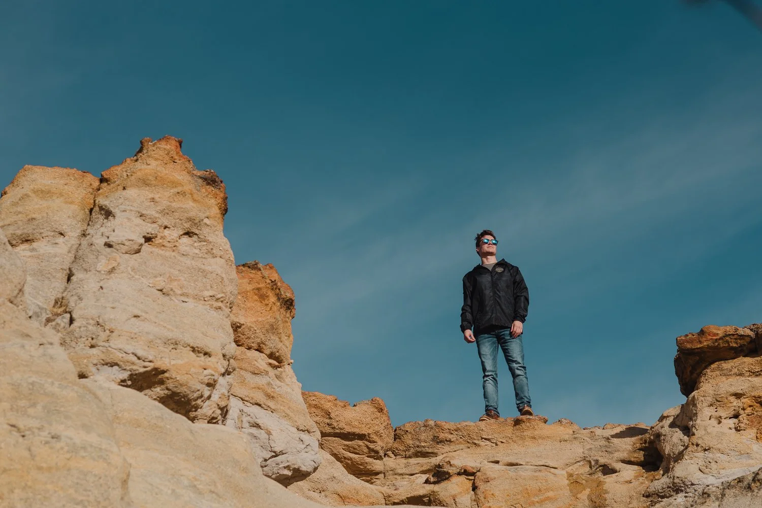 Lifestyle photography of young guy wearing a black windbreaker at Pulpit Rock Park in Colorado Springs, Colorado for Akinz Boardwear