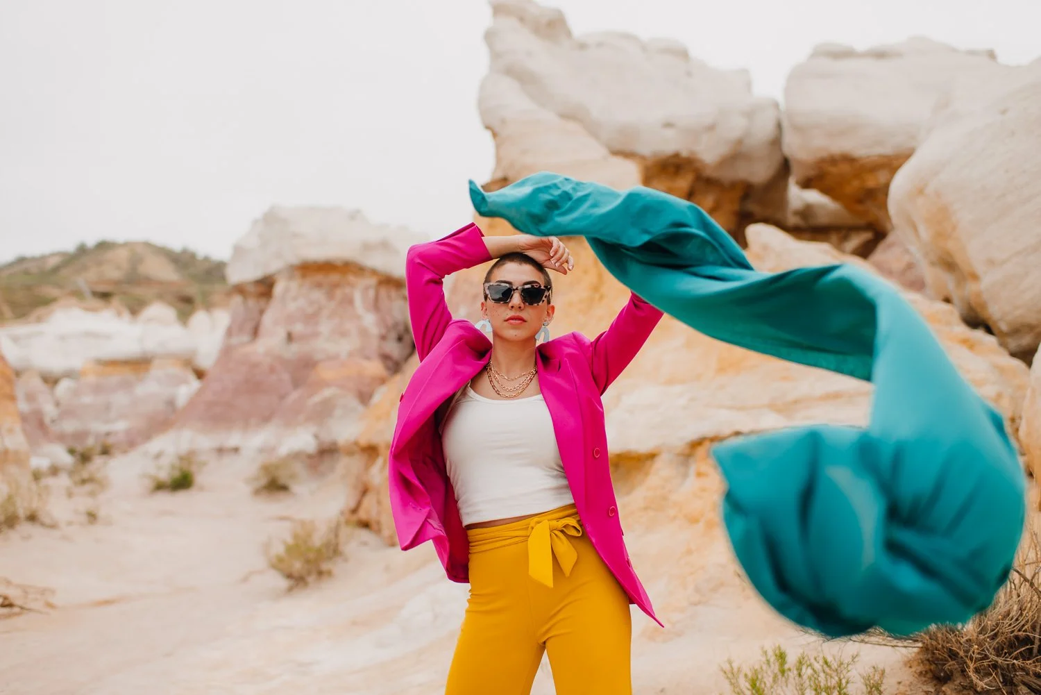 Professional editorial portrait photography at the Paint Mines Interpretive Park in Calhan, Colorado - colorful pink blazer, yellow pants