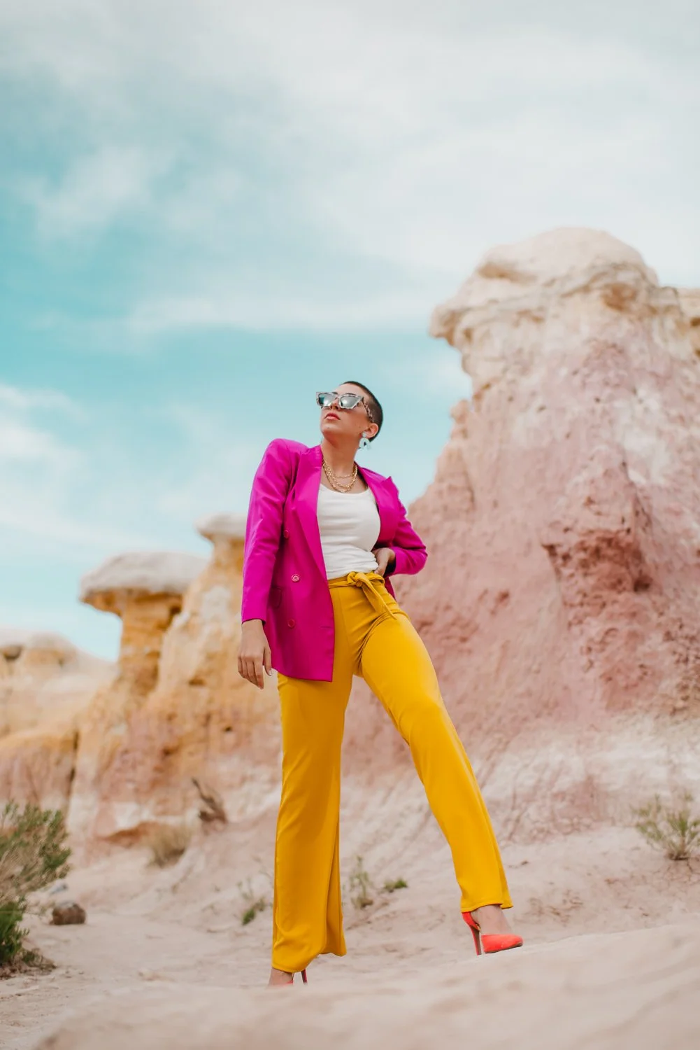 Professional editorial portrait photography at the Paint Mines Interpretive Park in Calhan, Colorado - colorful pink blazer, yellow pants